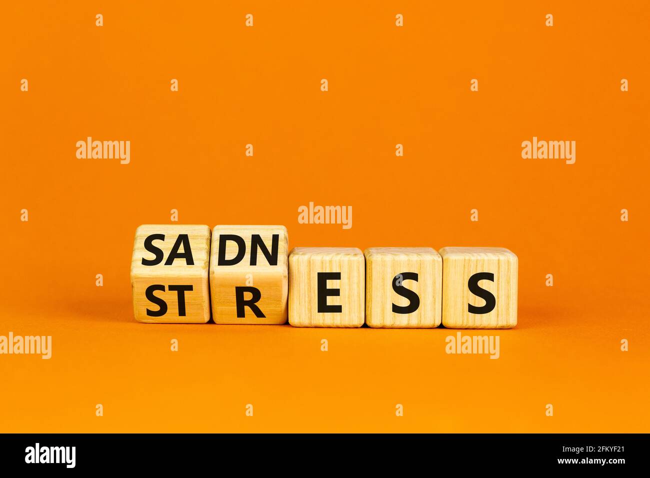 Symbol für Traurigkeit und Stress. Drehte Würfel und änderte das Wort "Stress" in "Adness". Schöner orangefarbener Tisch, orangefarbener Hintergrund. Medizinisch, psychologisch Stockfoto