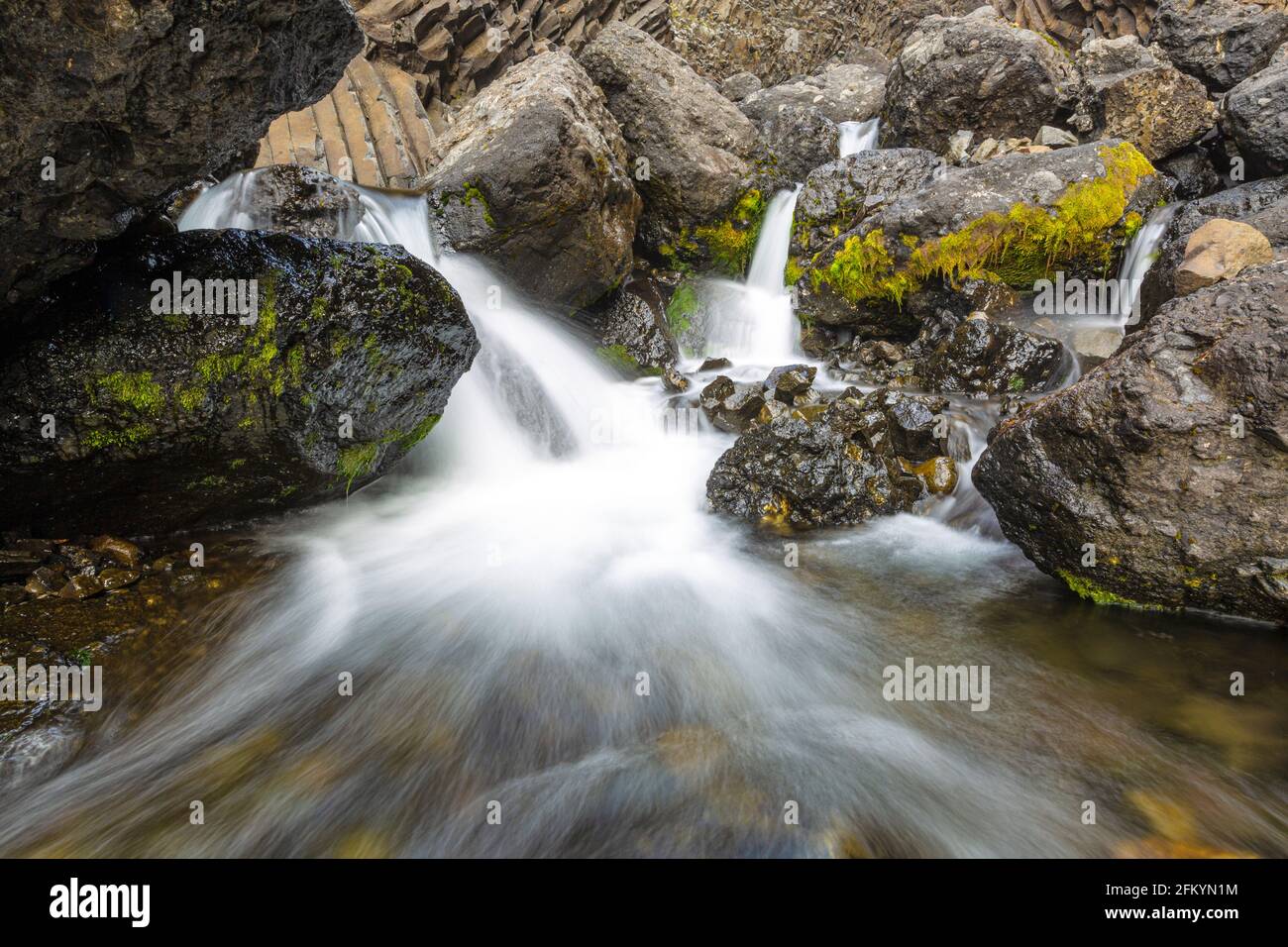 Kleiner Wasserfall durch säulenförmigen Basalt in Brededal, Disko Island, Qeqertarsuaq, Baffin Bay, Grönland. Stockfoto