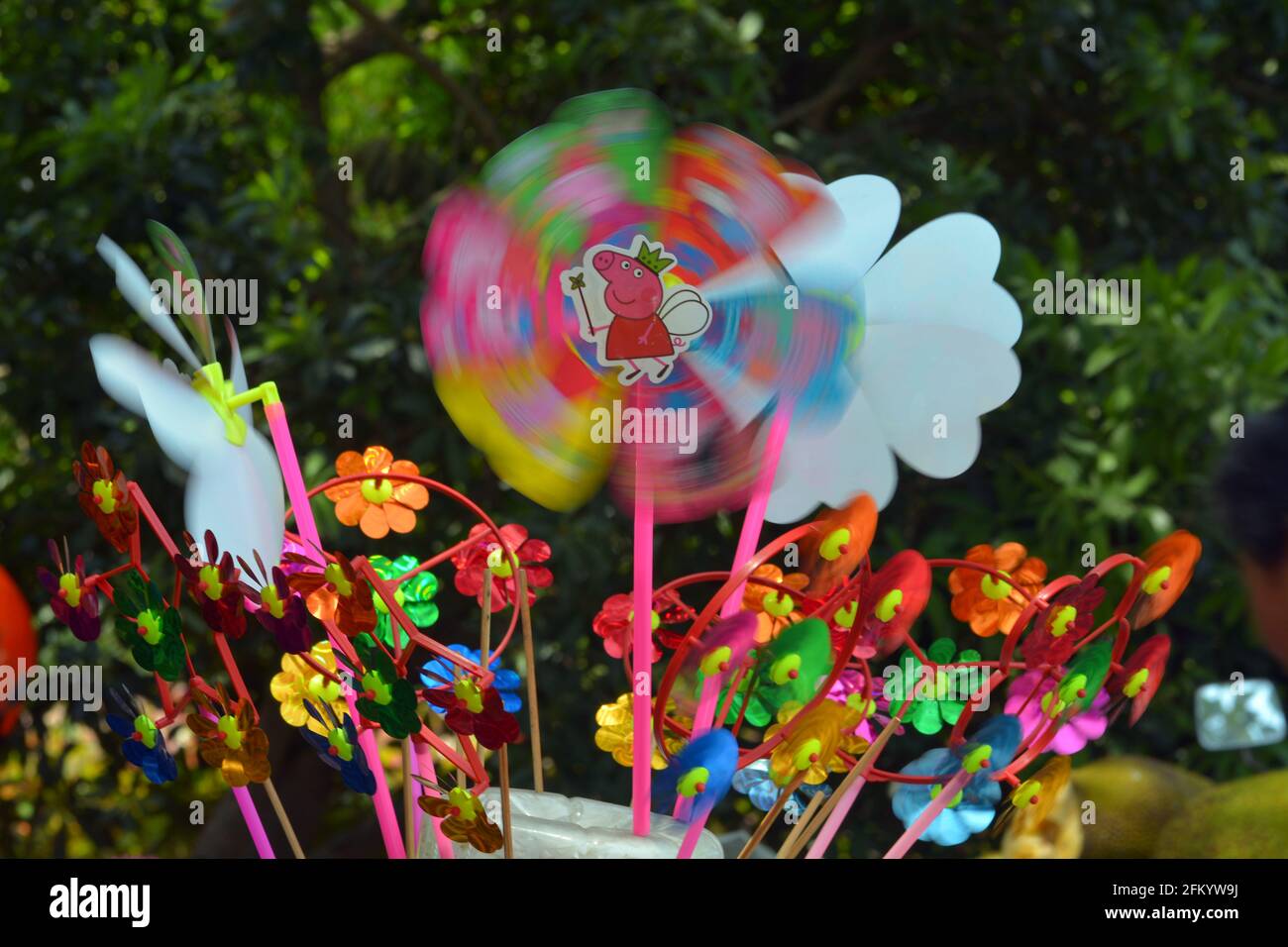 Bunte Kinderwindspinner oder Windrad, die im Wind weht. Diese Gruppe wurde an einem sonnigen Wochenende in einem chinesischen Park verkauft. Stockfoto