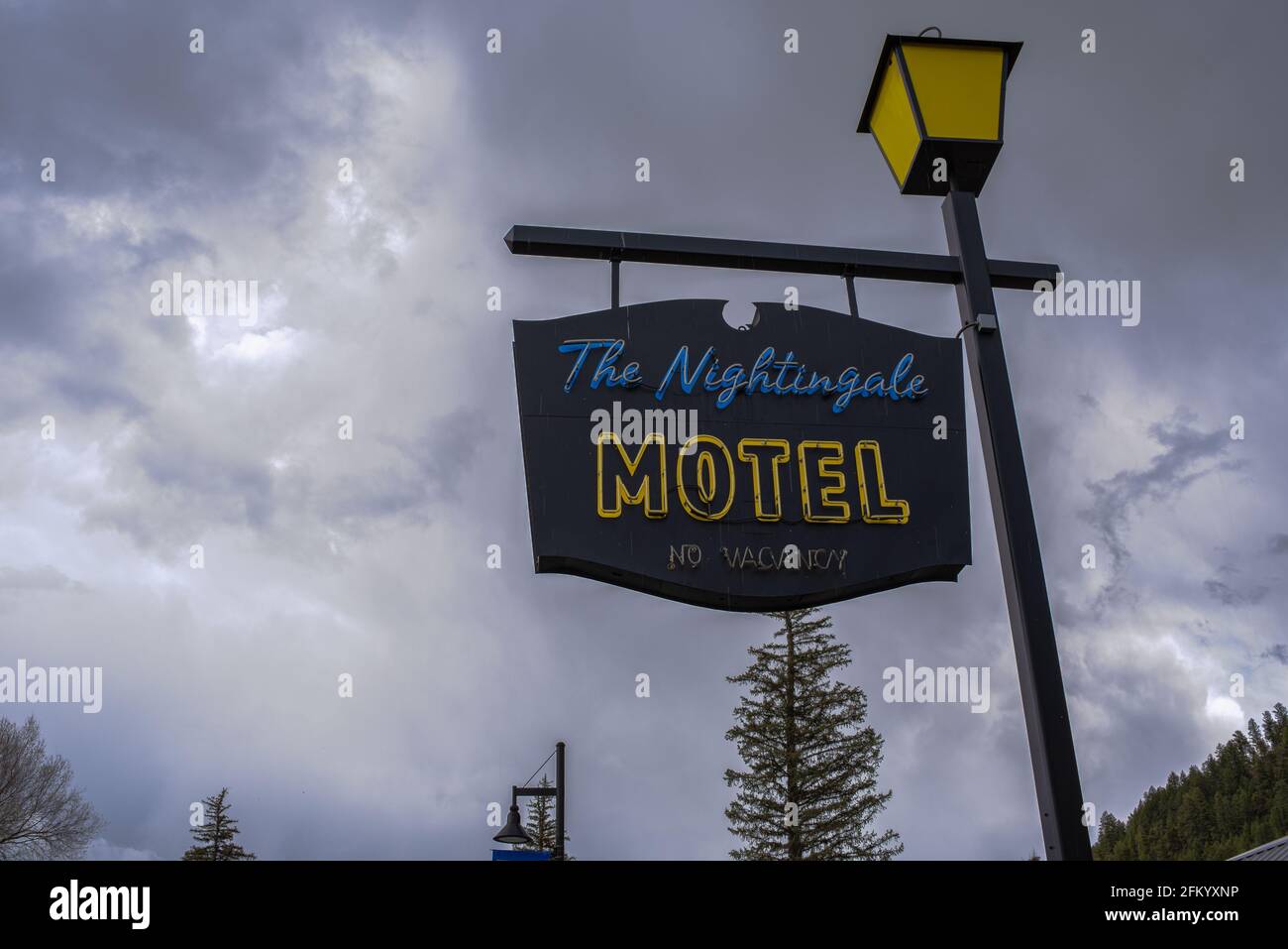 Ein schwarzes Schild für das Nightingale Motel, das an einer alten Straßenlampe hängt. Stockfoto