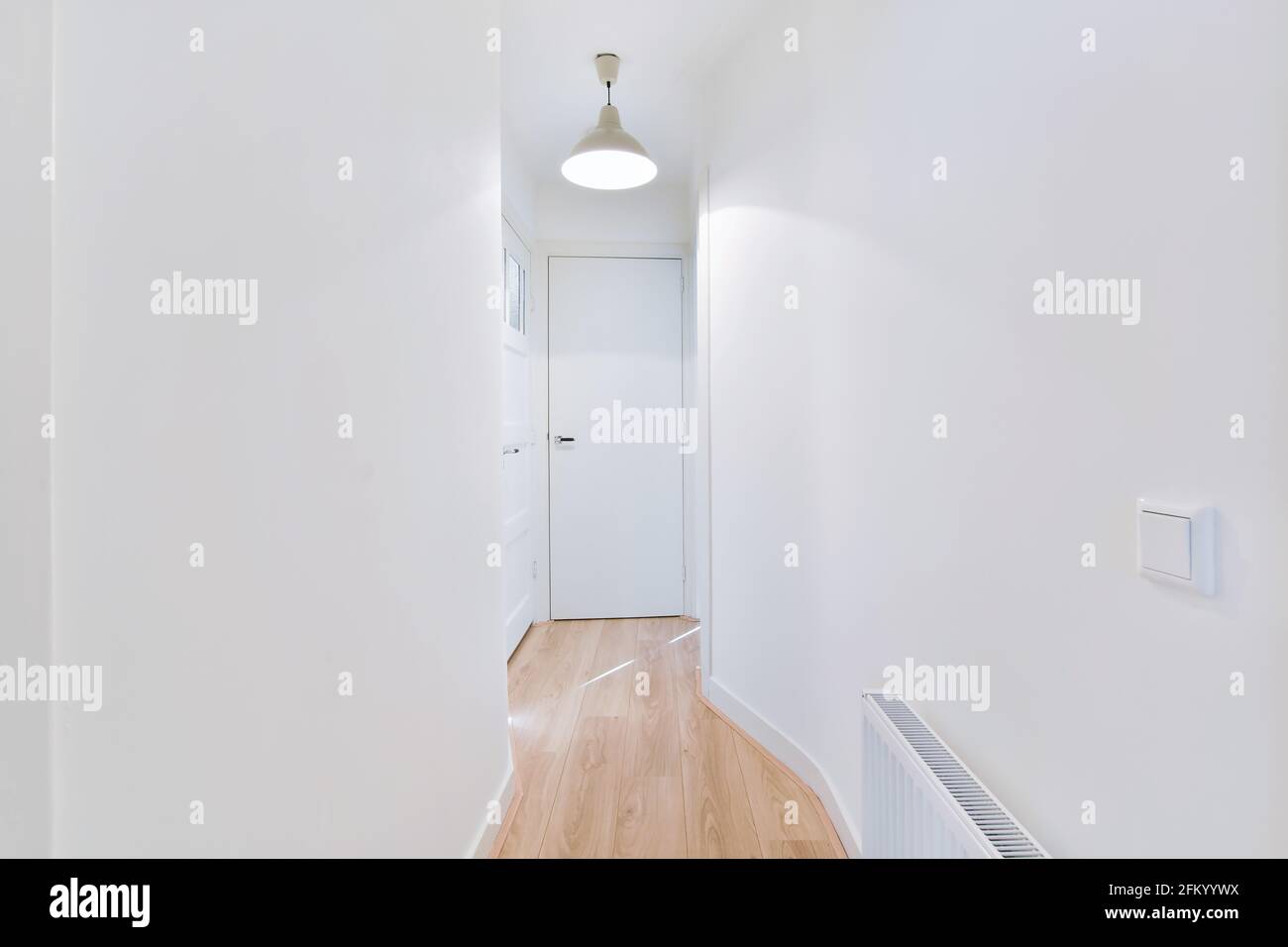 Langer Korridor mit weißen Wänden in der Wohnung Stockfoto