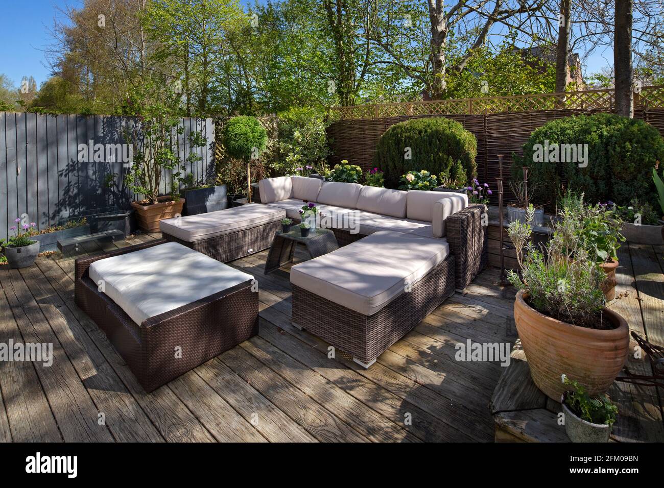 Rattan-Gartenmöbel in englischer Gartenumgebung Stockfoto