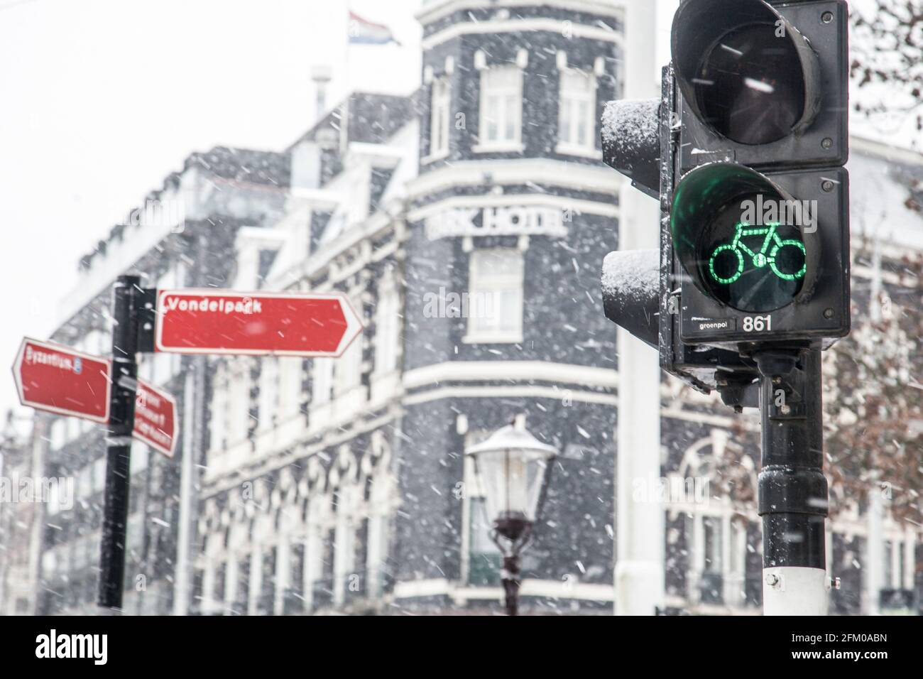 Ampel mit grünem Fahrradsymbol bei Schneefall, Amsterdam, Nordholland, Niederlande Stockfoto