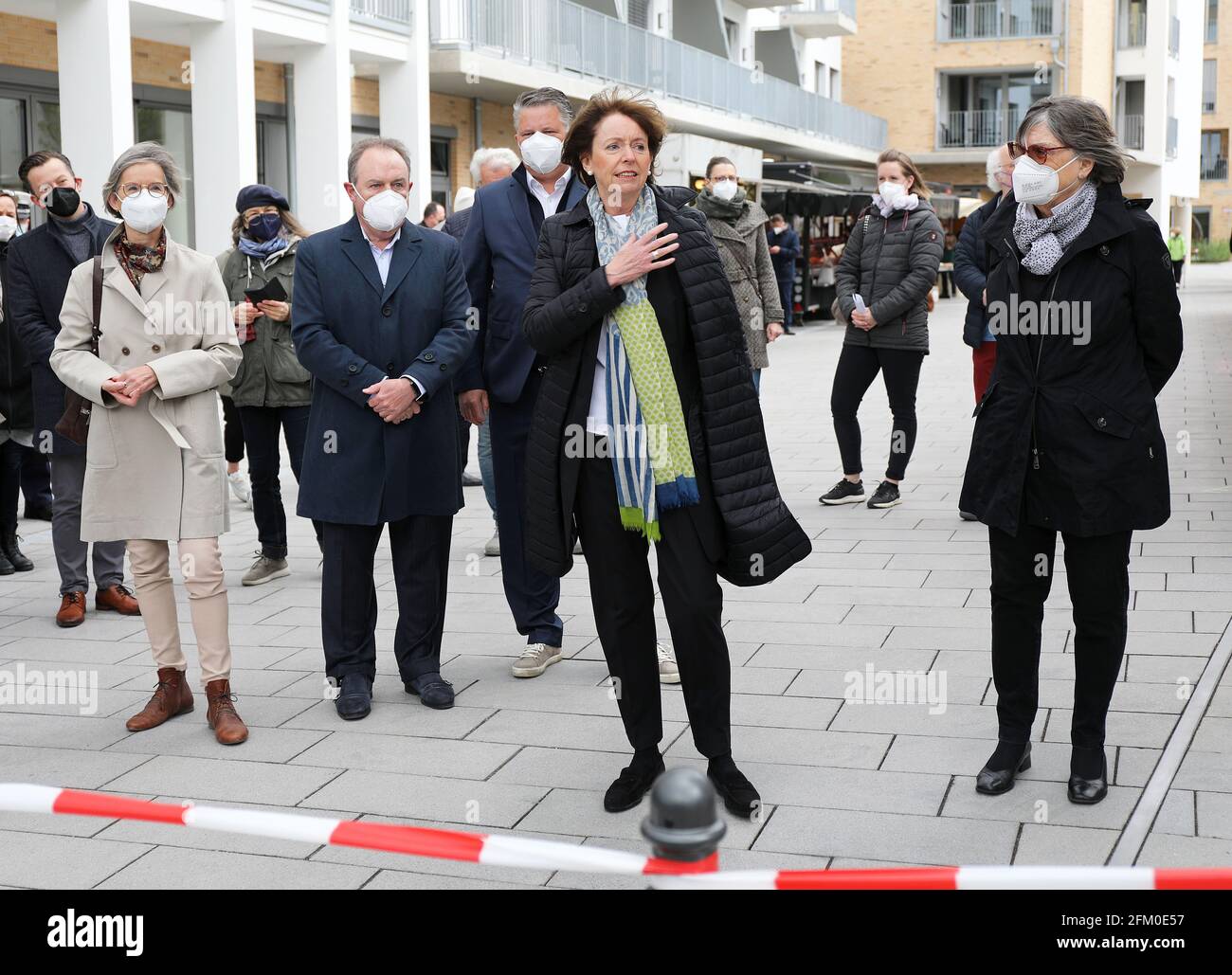 Köln, Deutschland. Mai 2021. Henriette Reker (M), Oberbürgermeisterin von Köln, geht mit Bürgern und Kommunalpolitikern durch den Clarenbachplatz. Rund fünfeinhalb Jahre nach dem Messerangriff auf den Oberbürgermeister von Köln gedachte der Parteienlose an den Anschlag am Ort des Vorfalls. Der 64-Jährige besuchte die Wiedereröffnung eines Wochenmarktes im Stadtteil Braunsfeld. (Zur dpa 'Cologne Mayor Reker besucht den Ort ihres Attentats') Quelle: Oliver Berg/dpa/Alamy Live News Stockfoto