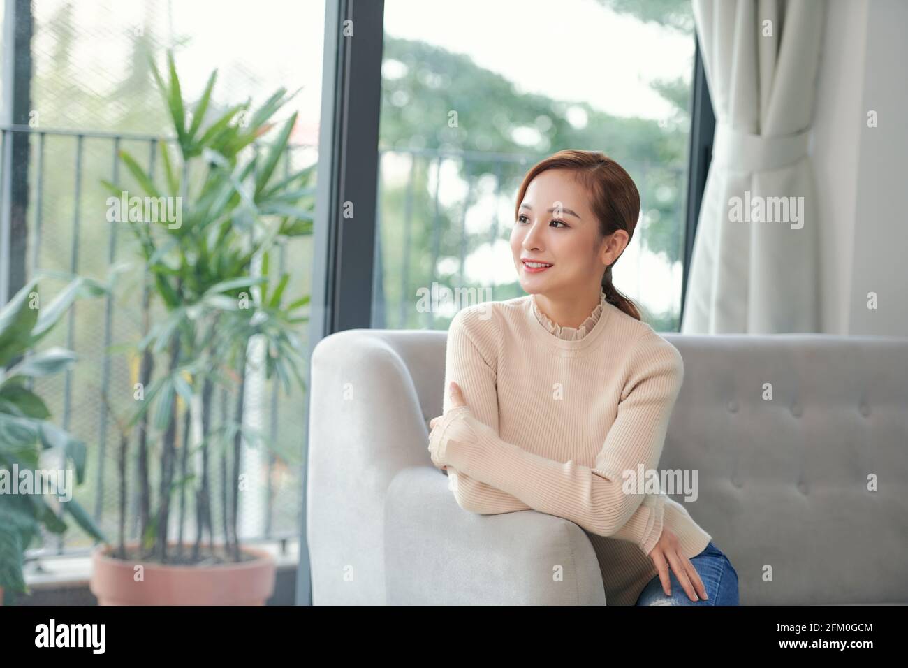 Zufriedene junge Dame, die Freude an stressfreien Wochenende Morgen Strecken auf der Couch Stockfoto