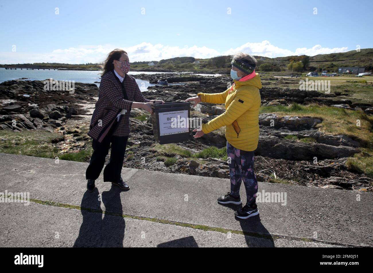 Shona Barton, ein Mitglied des Teams des Rückkehrbüros aus dem Argyll- und Bute-Rat mit Wahlurnen, als sie auf der Isle of Gigha ankommt, wo sie sie dem Präsidialbeamten Morven Beagan(r) zur Verwendung im Wahllokal auf der Isle of Gigha aushändigen wird, Vor der Abstimmung bei den schottischen Parlamentswahlen am Donnerstag. Bilddatum: Dienstag, 4. Mai 2021. Stockfoto