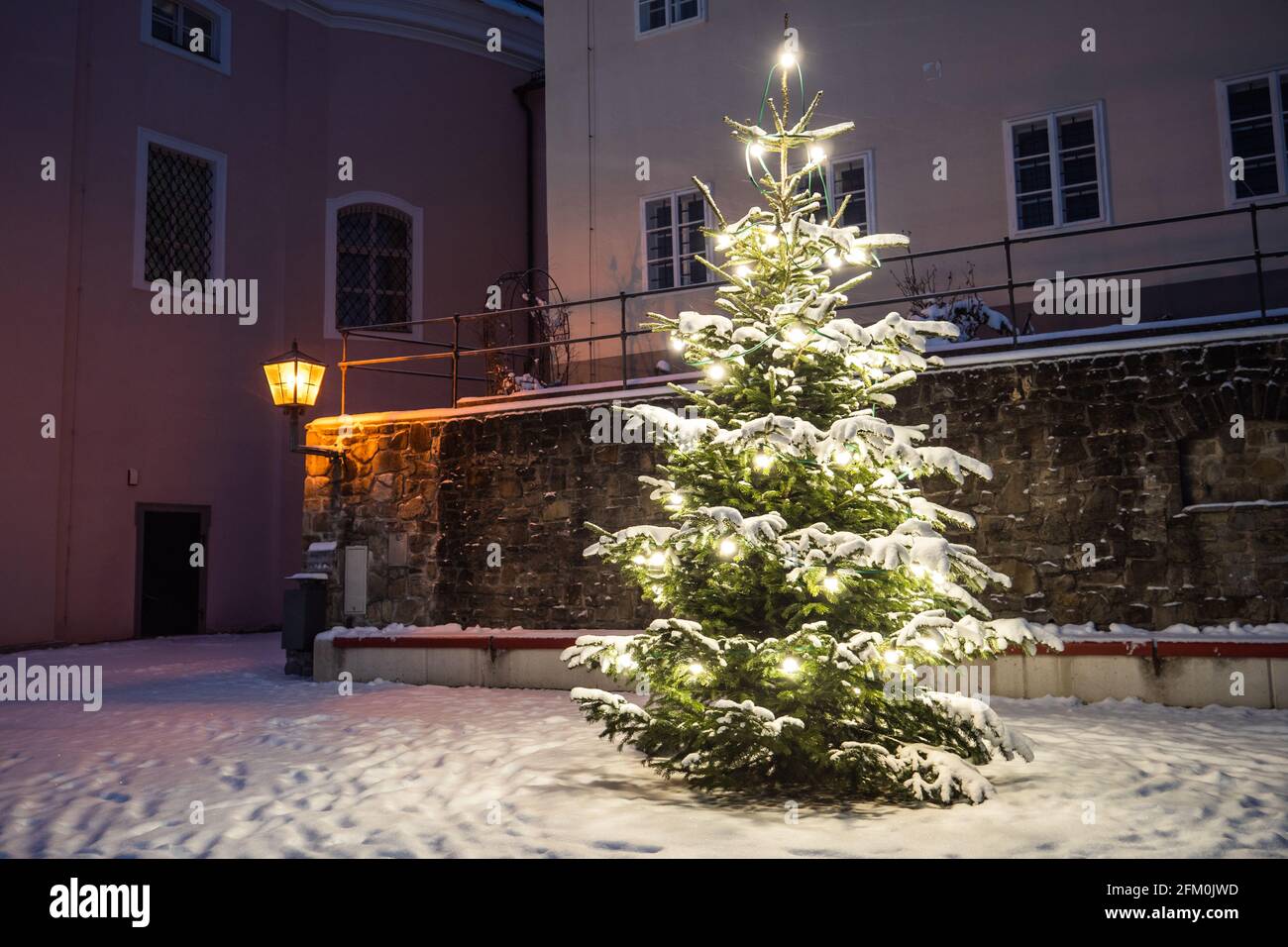 Weihnachtsbaum draußen im Schnee beleuchtet in einer kalten Winternacht in der Sonntagberger Basilikumkirche, Mostviertel, Niederösterreich, ein Weihnachtskonzept Stockfoto