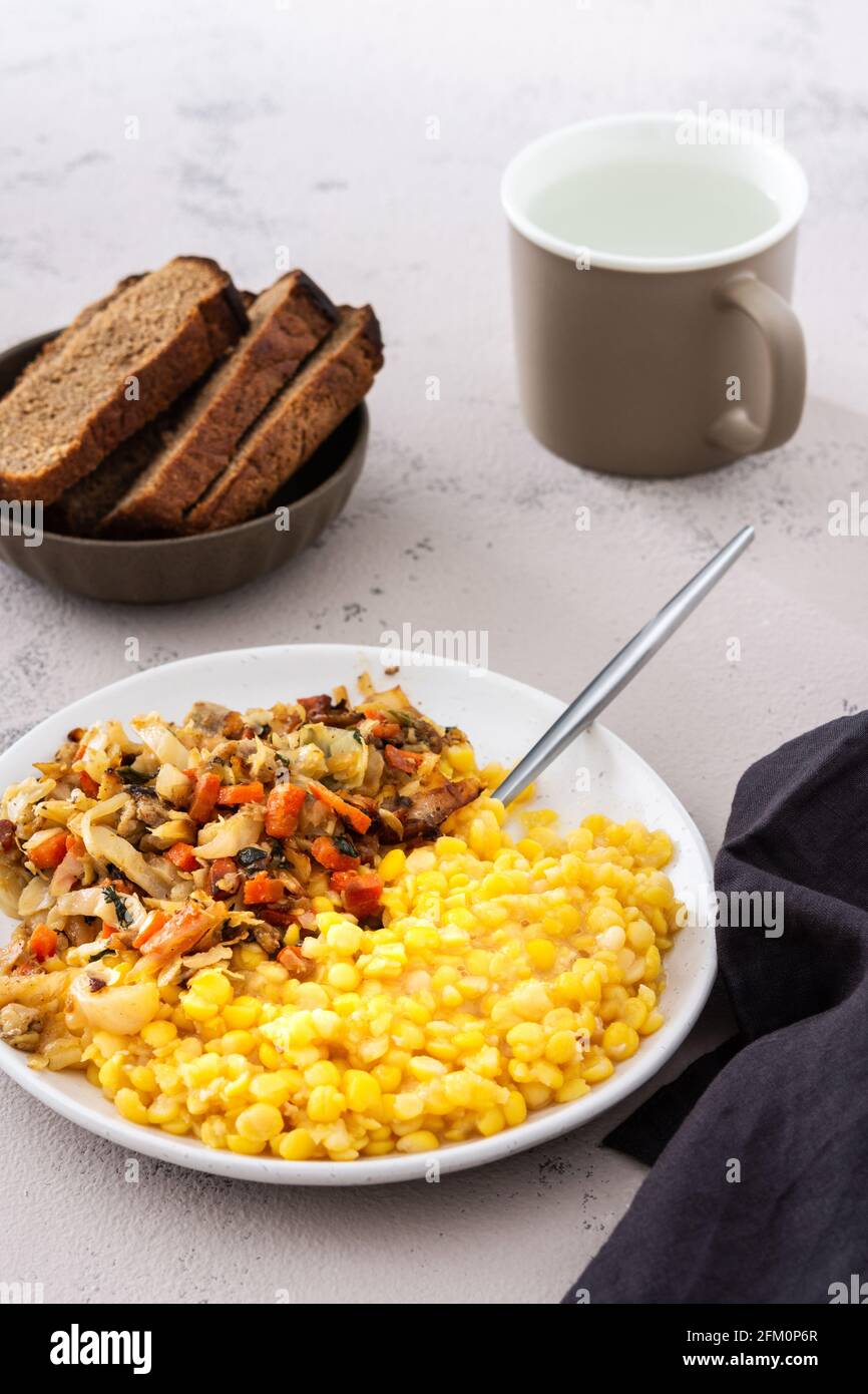 Köstliches herzhaftes Mittagessen, Erbsenbrei mit Kohl, Karotten und Fleischragout Stockfoto