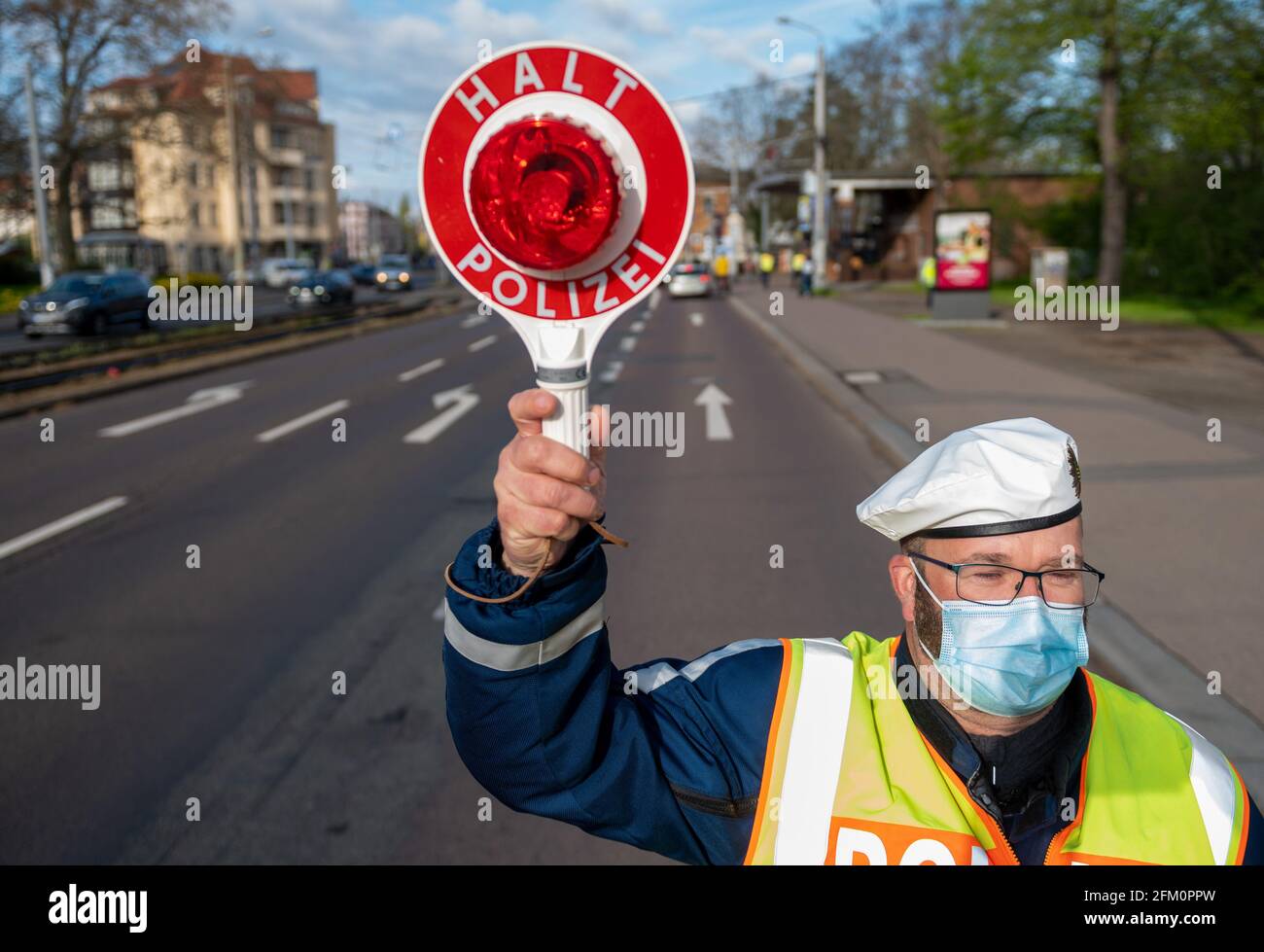 Leipzig, Deutschland. Mai 2021. Ein Polizeibeamter der Leipziger Verkehrspolizei hält einen Autofahrer in der Jahnallee in Leipzig an. Die Kontrollen führt die Leipziger Polizei im Rahmen der bundesübergreifenden Verkehrssicherheitskampagne sicher.mobil.leben durch. Ziel ist es, die Straßenverkehrssicherheit für alle Verkehrsträger zu erhöhen, die am Straßenverkehr beteiligt sind. Quelle: Hendrik Schmidt/dpa-Zentralbild/ZB/dpa/Alamy Live News Stockfoto