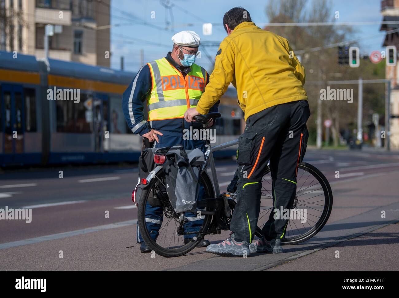 Leipzig, Deutschland. Mai 2021. Ein Polizeibeamter der Leipziger Verkehrspolizei überprüft einen Radfahrer in der Jahnallee in Leipzig. Die Kontrollen führt die Leipziger Polizei im Rahmen der bundesübergreifenden Verkehrssicherheitskampagne sicher.mobil.leben durch. Ziel ist es, die Straßenverkehrssicherheit für alle Verkehrsträger zu erhöhen, die am Straßenverkehr beteiligt sind. Quelle: Hendrik Schmidt/dpa-Zentralbild/ZB/dpa/Alamy Live News Stockfoto