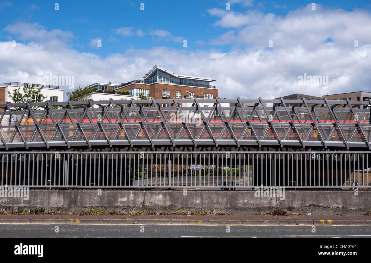 Kingston upon Thames London, Mai 04 2021, Eisenbahnzug auf EINER Brücke mit Luxuswohnungen oder Apartments im Backgorund unter BLAUEM Wolkenhimmel Stockfoto