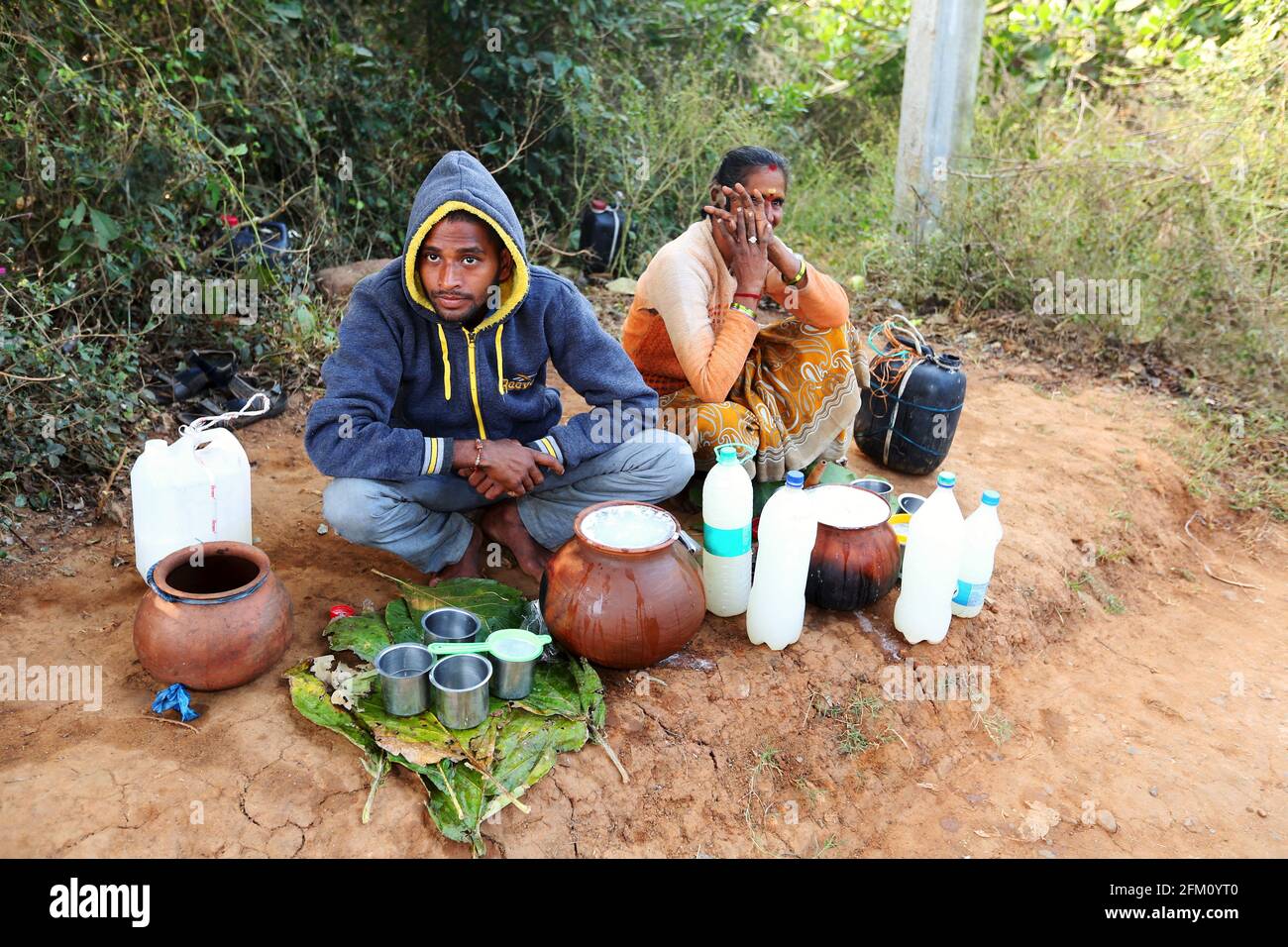 Stammesleute, die Dattelpalmwein, Madhi- und Palmwein verkaufen, werden auf einem Wochenmarkt im Dorf Seethampeta, Andhra Pradesh, Indien, verkauft Stockfoto