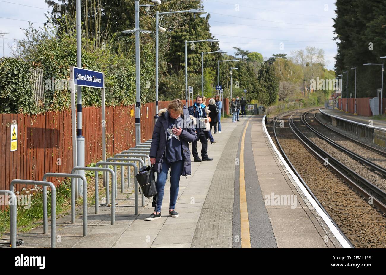Passagiere warten auf dem Bahnsteig an den Bahnhöfen Cobham und Stoke D'Abernon, Surrey, Großbritannien Stockfoto