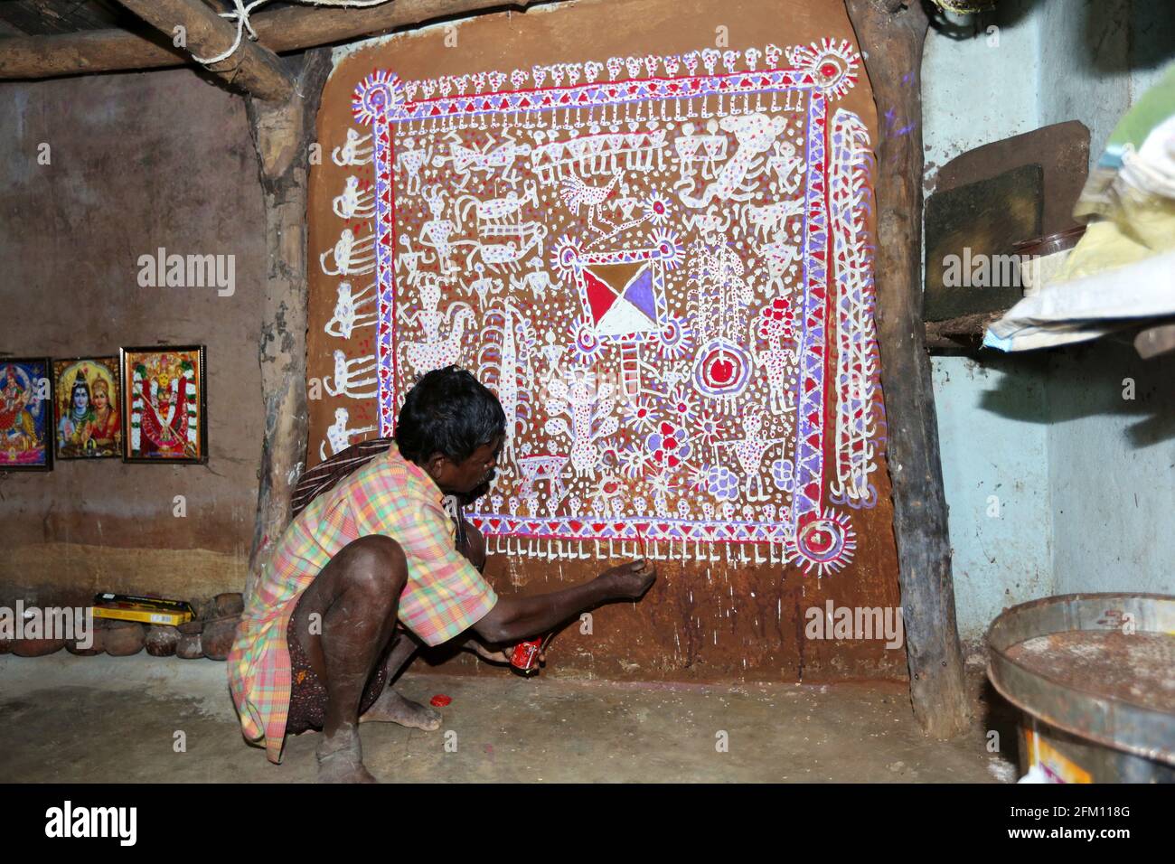 Stammeskünstler, der traditionelle Savara-Malerei an Hauswand im Dorf Masaguda im Bezirk Srikakulam, Andhra Pradesh, Indien, macht. SAVARA-STAMM Stockfoto
