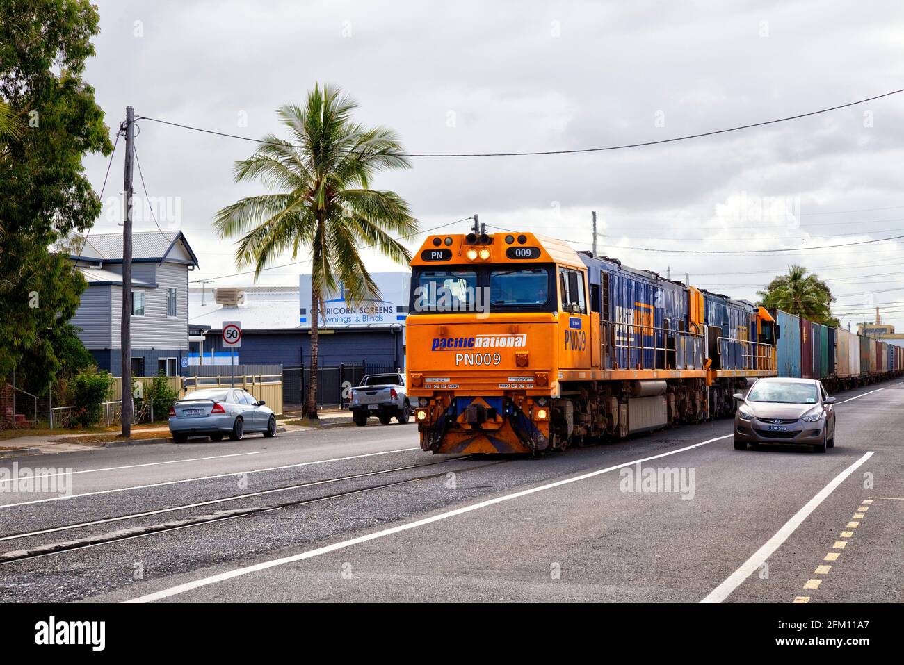 Einzigartige Denison Street, in der sich die Haupteisenbahn den Platz teilt Autoverkehr Rockhampton Queensland Australien Stockfoto