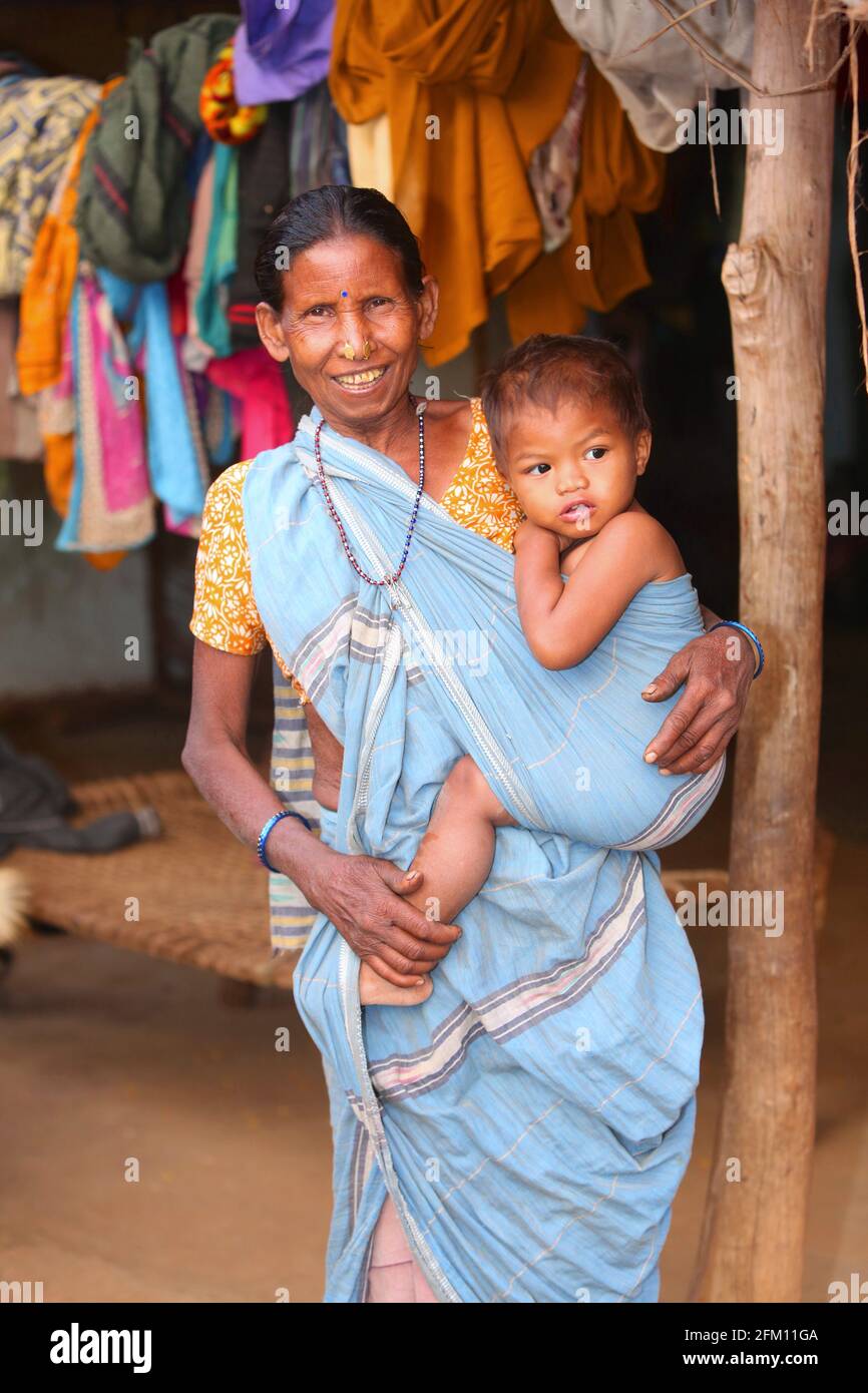 Großmutter trägt ihren Enkel im Dorf Masaguda, Bezirk Srikakulam, Andhra Pradesh, Indien. SAVARA-STAMM Stockfoto