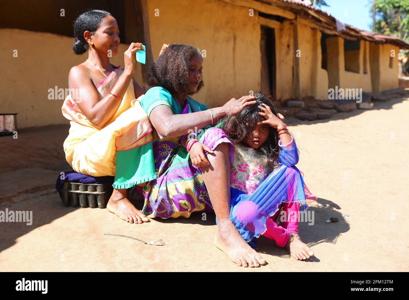 Stammesfrauen, die im Dorf Sainagar in Araku, Andhra Pradesh, Indien, mit Haarkämmen beschäftigt sind Stockfoto