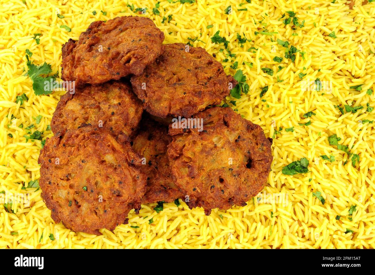 Traditionelle indische Zwiebel-Bhajis mit Pilau-Reis-Hintergrund Stockfoto