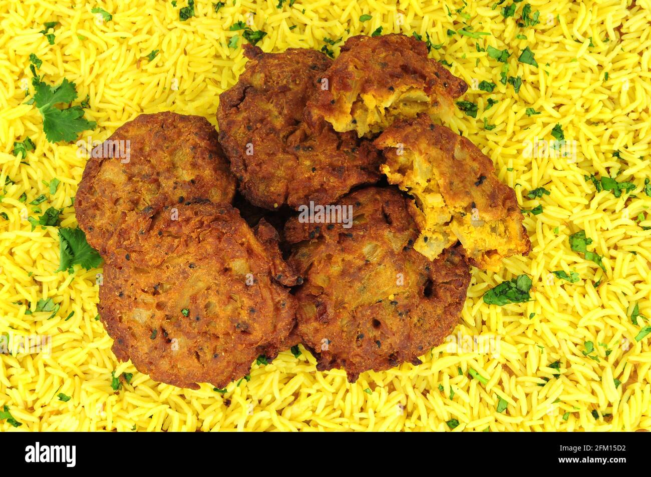 Traditionelle indische Zwiebel-Bhajis mit Pilau-Reis-Hintergrund Stockfoto
