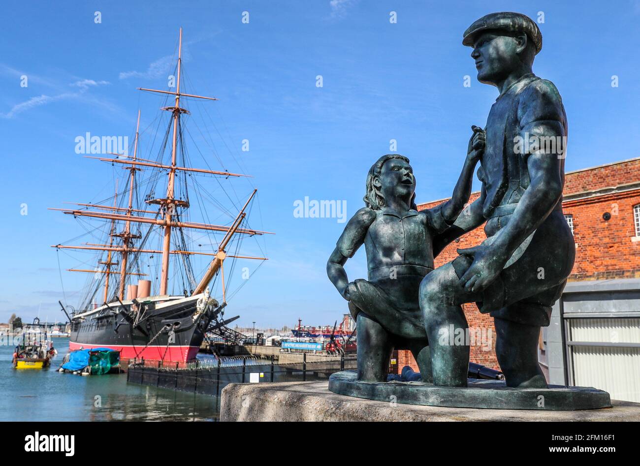 Die Mudlarks-Statue, die harte, Portsmouth mit HMS Warrior im Hintergrund, Portsmouth, Hampshire, Großbritannien. Stockfoto