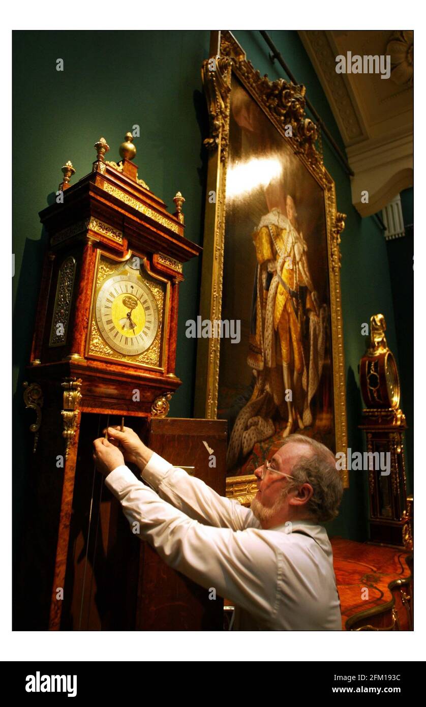 Die erste Ausstellung über King George III und Queen Charlotte wird in der Queens Gallery, Buckingham Palace, eröffnet. Robert Ball der Queens Uhrmacher mit der Longcase Gleichungsuhr von Thomas Tompion, die 390 Tage lang auf einem einzigen Aufzug läuft und von einem Gewicht von 86 kg gesteuert wird.pic David Sandison 25/3/2004 Stockfoto