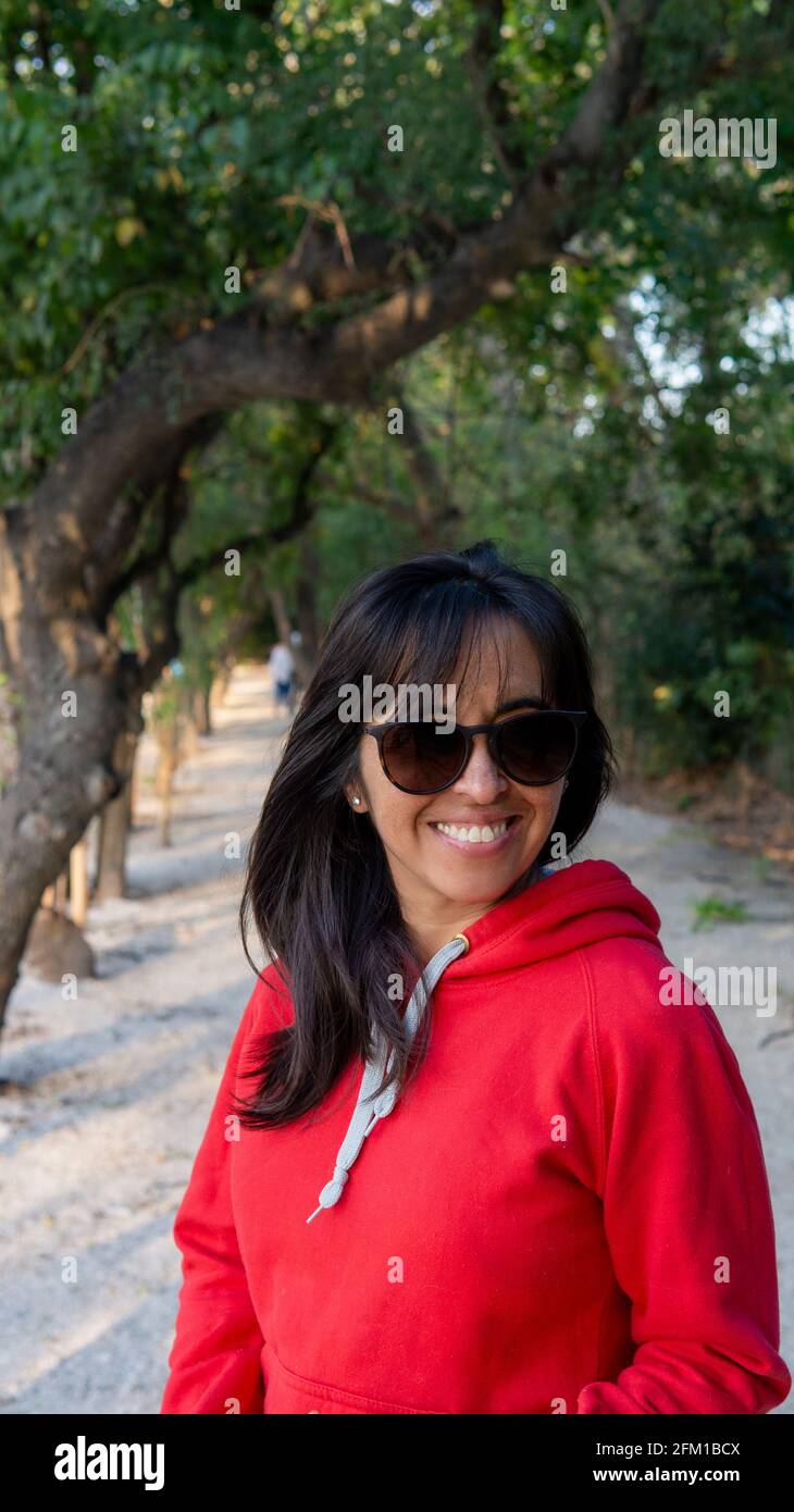 Porträt einer jungen Frau in einer grünen Sonnenbrille park bei Sonnenuntergang Stockfoto