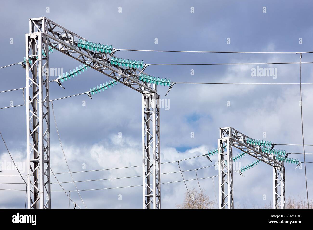 Zwei elektrische Hochspannungsübertragung H-Rahmen-Türme Masten Einzelschaltung drei Phasen durch Isolatoren über bewölktem stürmischen dunklen Himmel unterstützt. Stockfoto