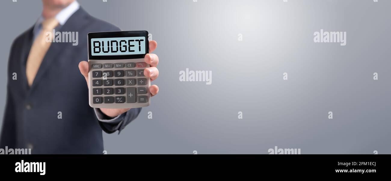 Budgetkonzept Budgettext auf Rechner. Nahaufnahme beschnittenes Bild Geschäftsmann Berechnung der monatlichen Ausgaben, Verwaltung des Budgets. Geschäftsmann zeigt Kalkül Stockfoto
