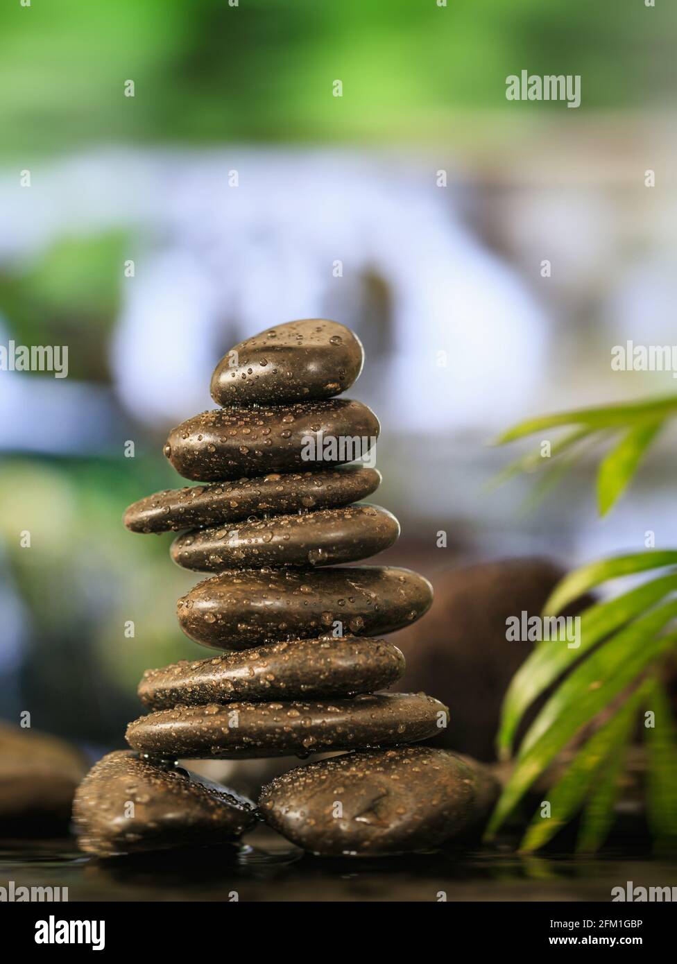 Buddhistisches Meditationskonzept. Zen-Steine mit Wassertropfen auf abstraktem Hintergrund gestapelt. Gleichgewicht zwischen Geist, Körper und Seele führen zu dem Erwerb o Stockfoto