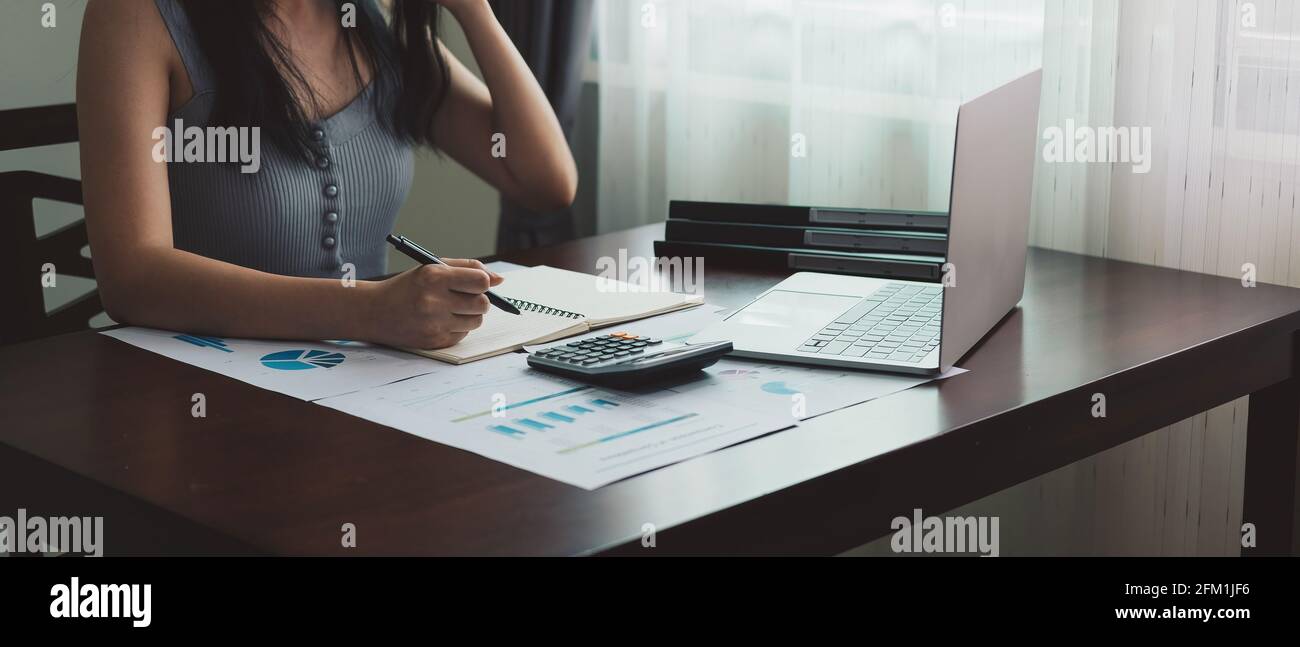 Frau Hand schreibt auf einem Notizbuch mit einem Stift Für die Finanzbuchhaltung zu Hause Stockfoto