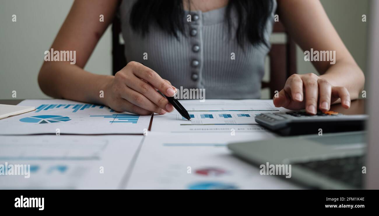 Geschäftsfrau, die im Finanz- und Rechnungswesen arbeitet, analysiert das Finanzbudget Mit Rechner und Laptop zu Hause Stockfoto