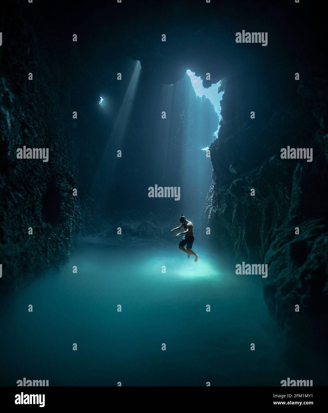 MENORCA, SPANIEN: Victor spielt mit dem Licht herum, wenn es ins Wasser trifft und eindringt. ATEMBERAUBENDE Unterwasseraufnahmen haben einen Freitaucher sw aufgenommen Stockfoto