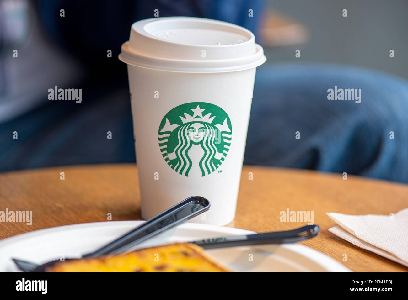 BERLIN - MAI 02: Weißer Papierbecher mit modernem Starbucks-Logo auf einem Tisch im Starbucks-Café in Berlin, Mai 02. 2021 in Deutschland Stockfoto