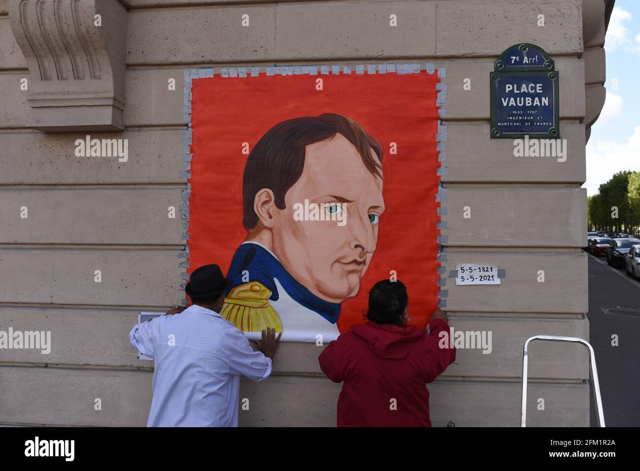 *** KEIN VERKAUF AN FRANZÖSISCHE MEDIEN ODER VERLAGE - RECHTE VORBEHALTEN ***05. Mai 2021 - Paris, Frankreich: Ein Künstler rollt ein Gemälde aus, das den französischen Kaiser Napoleon Bonaparte vor der Invalidenkirche zeigt, in der sich das Grab des Kaiser befindet, um den 200. Todestag zu feiern. Stockfoto