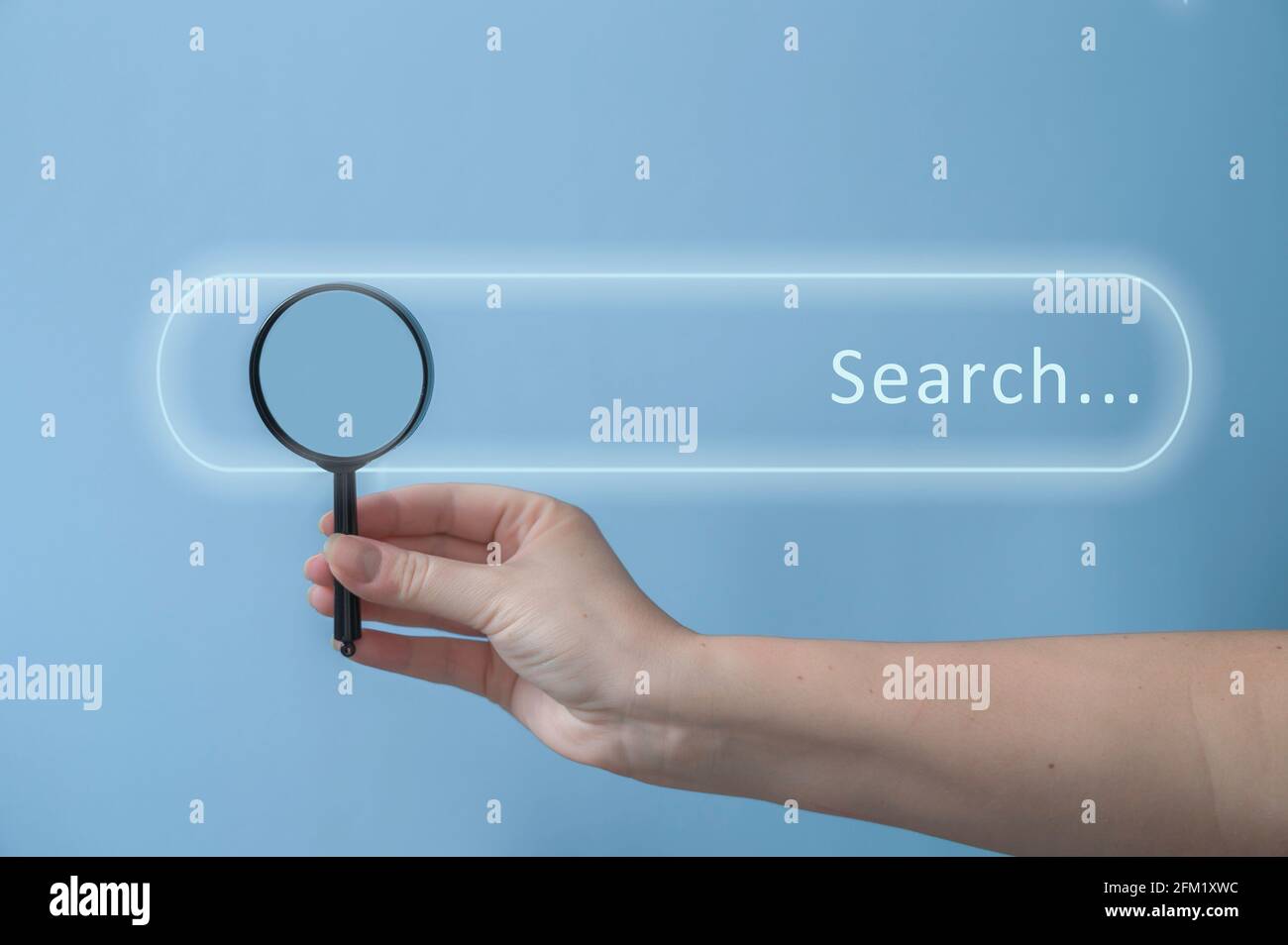 Weibliche Hand hält Lupe über pastellblauem Hintergrund. Suchleiste auf blauem Hintergrund. Web-Suchkonzept. Stockfoto