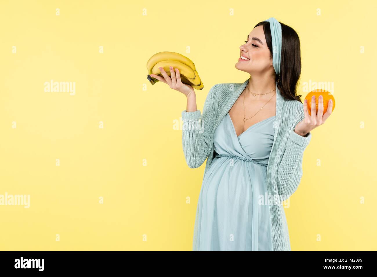 Freudige Schwangere hält reife Bananen isoliert auf gelb Stockfotografie -  Alamy