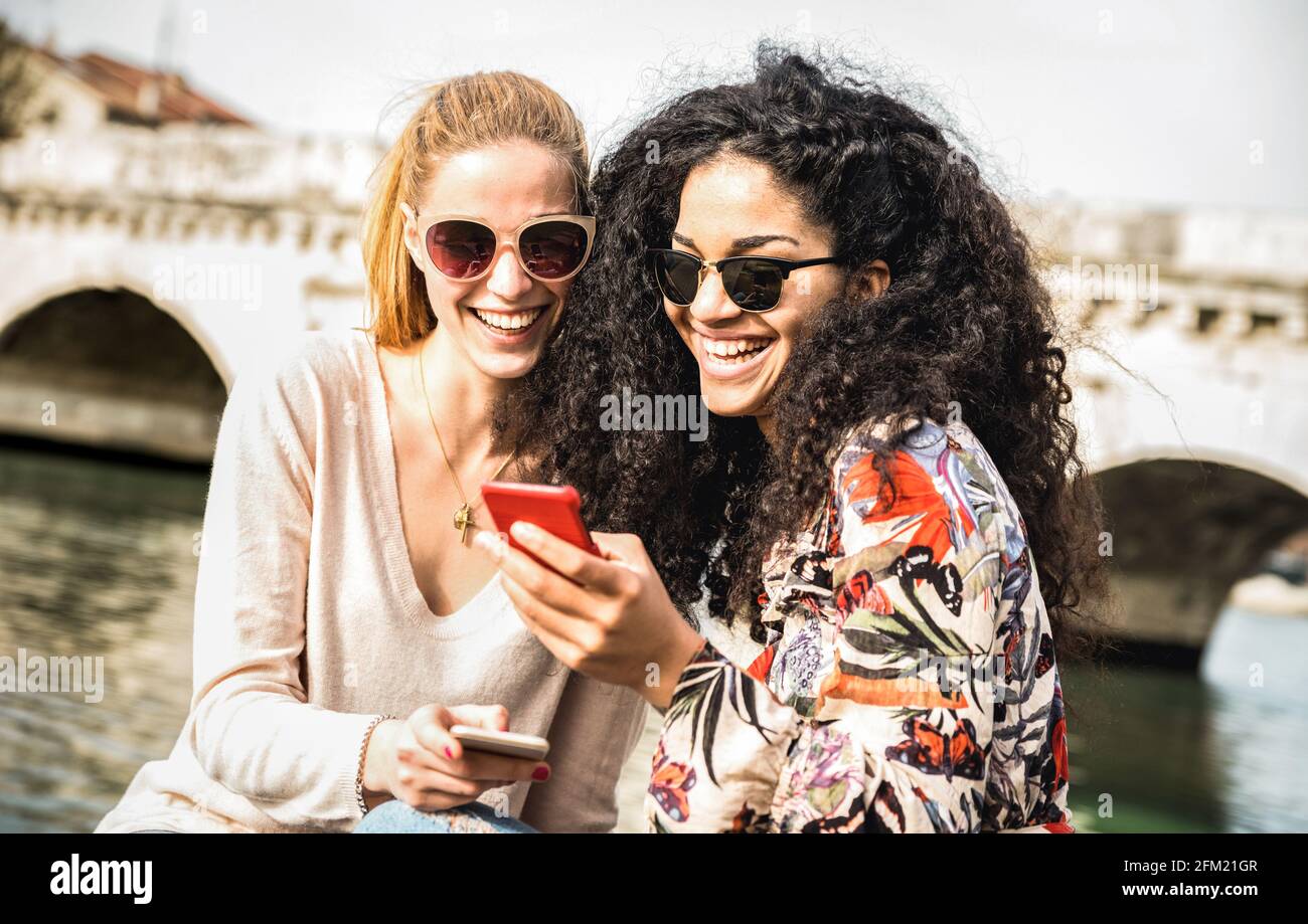 Glückliche multirassische Freundinnen, die Spaß haben Outddors mit Handy - Freundschaftskonzept mit Mädchen in den Frühlingsferien reisen Stockfoto