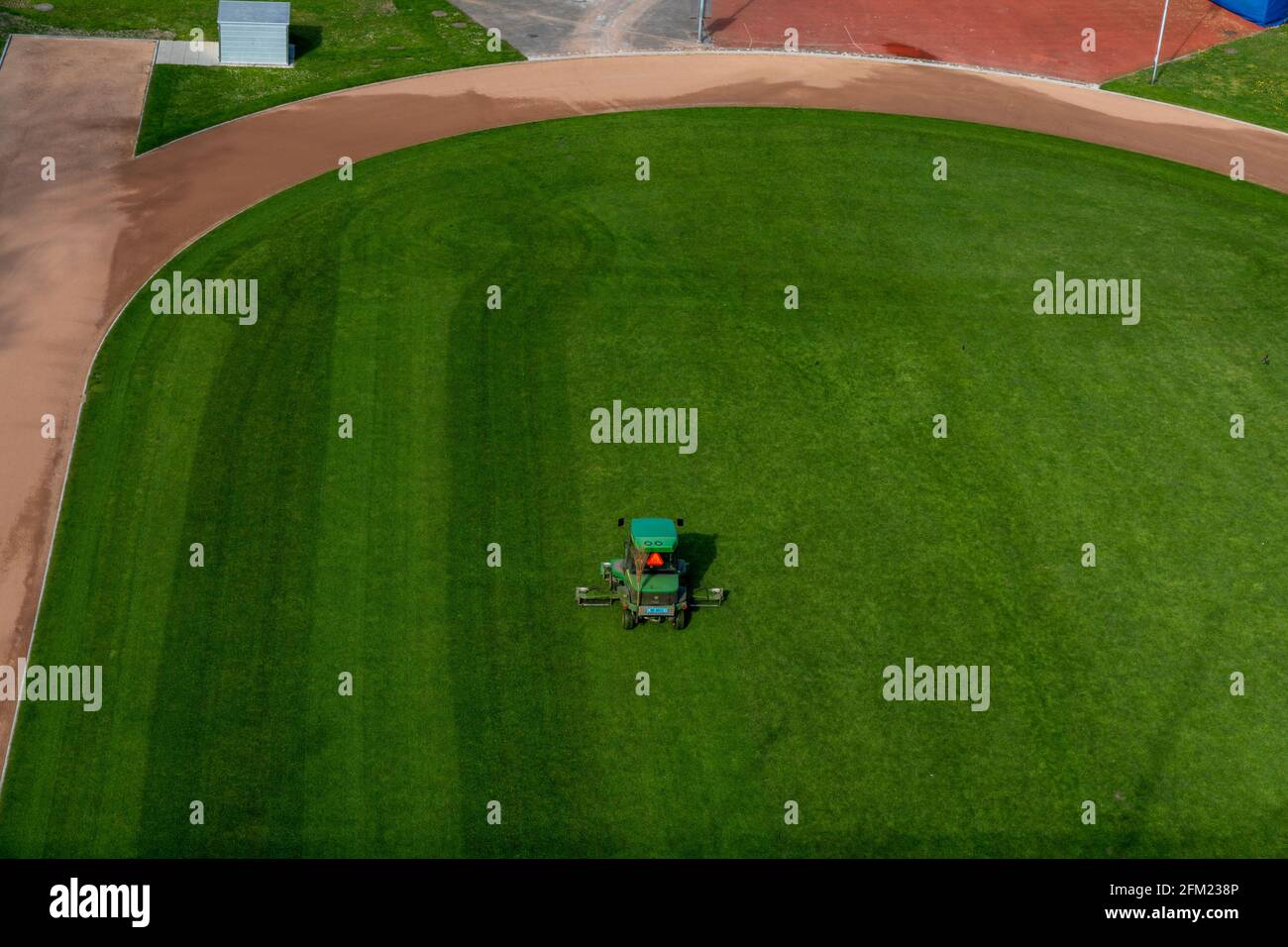 Bern, Schweiz - 26. April 2021: Eine Fahrt mit dem Rasenmäher, der Gras auf einem Fußballfeld schneidet Stockfoto