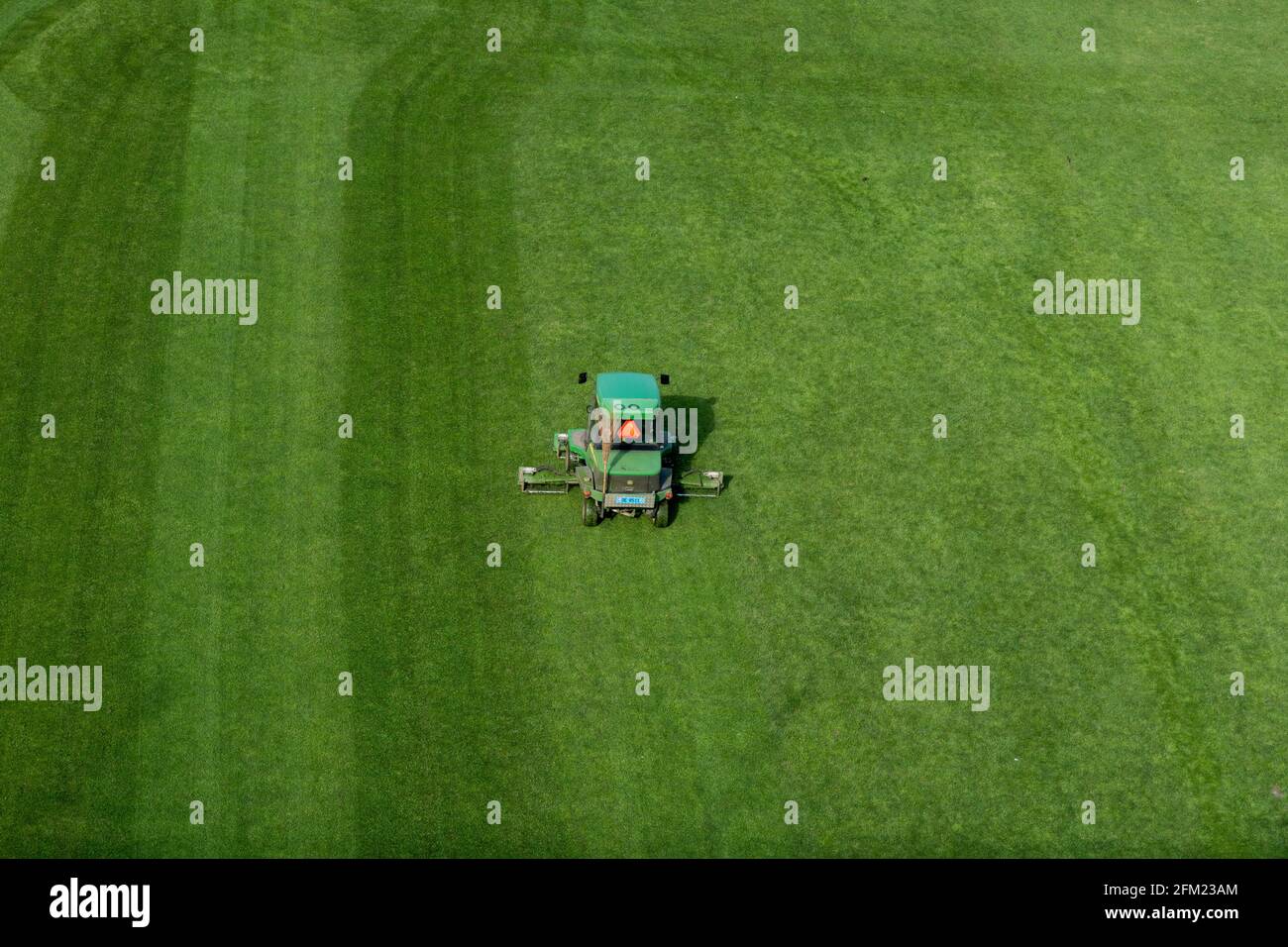 Bern, Schweiz - 26. April 2021: Eine Fahrt mit dem Rasenmäher, der Gras auf einem Fußballfeld schneidet Stockfoto