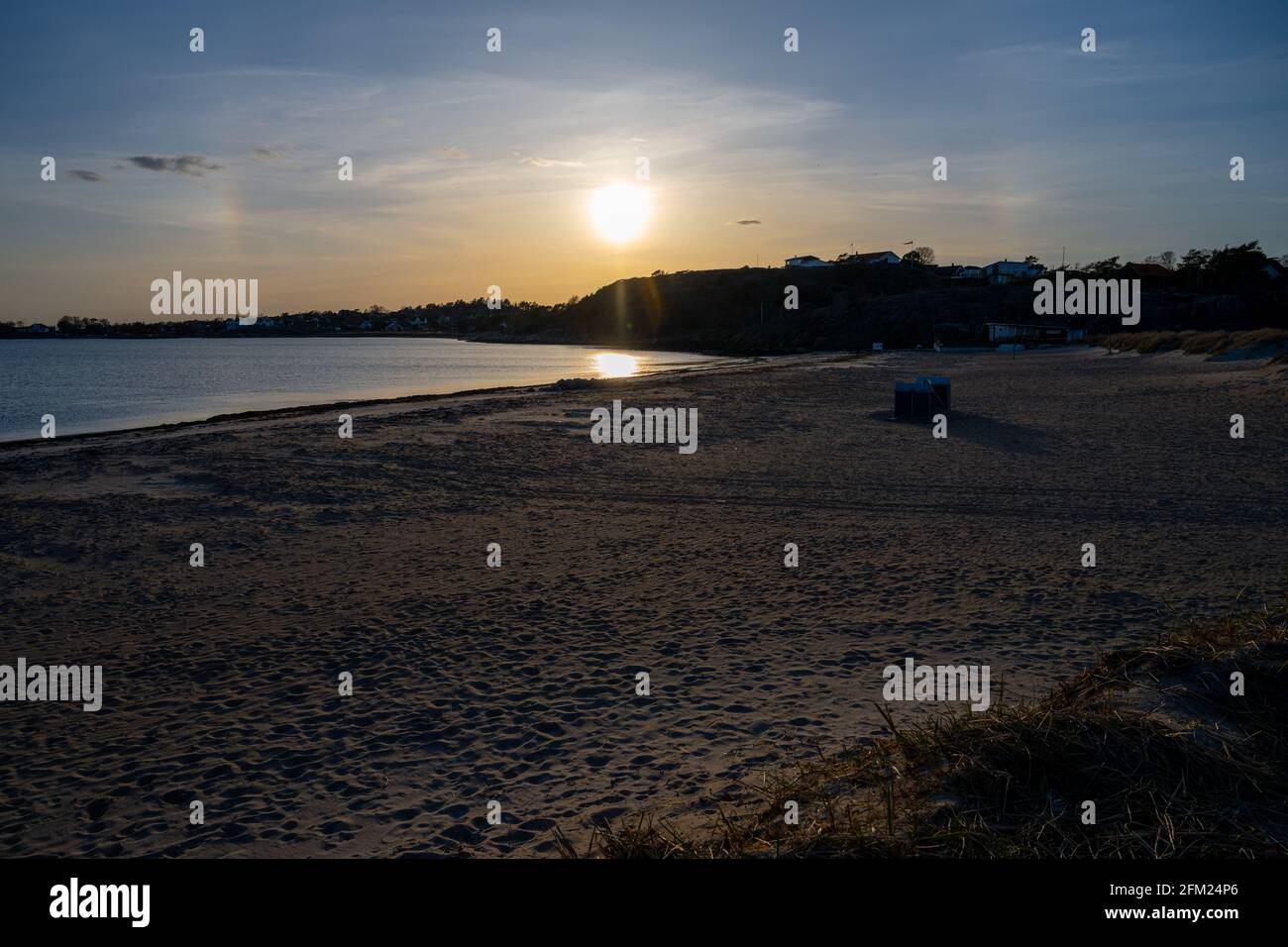 Ein wunderschöner orangefarbener Sonnenuntergang über einer Meeresbucht. Die Sonne spiegelt sich im Wasser. Bild von der schwedischen Westküste Stockfoto