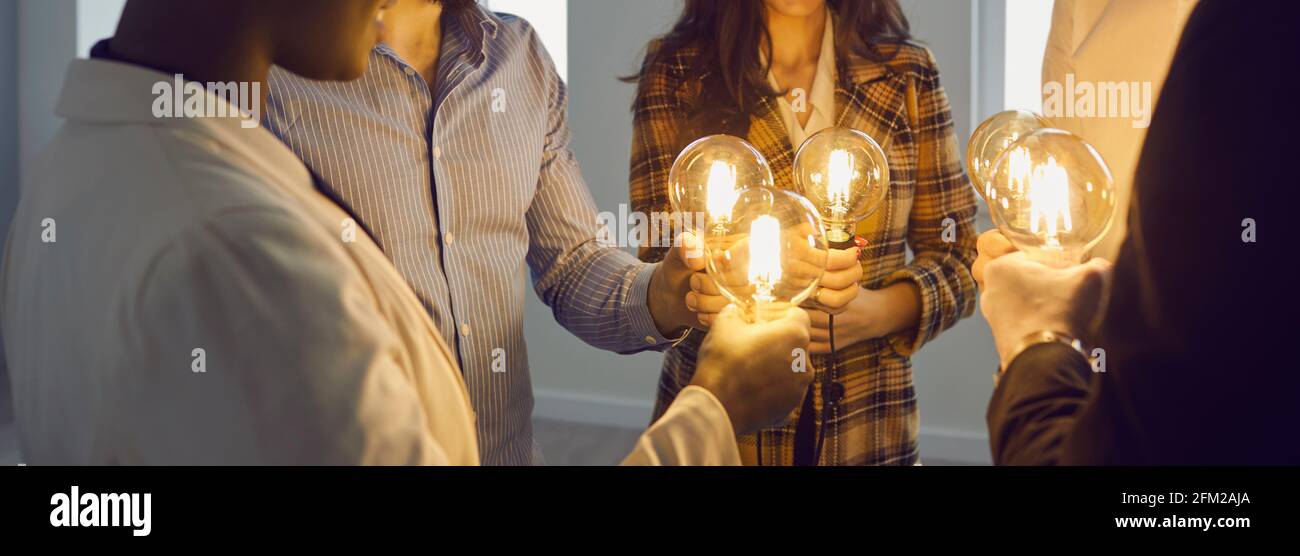 Geschäftsleute verbinden Glühbirnen als Metapher für den Austausch von Ideen In der kreativen Gemeinschaft Stockfoto