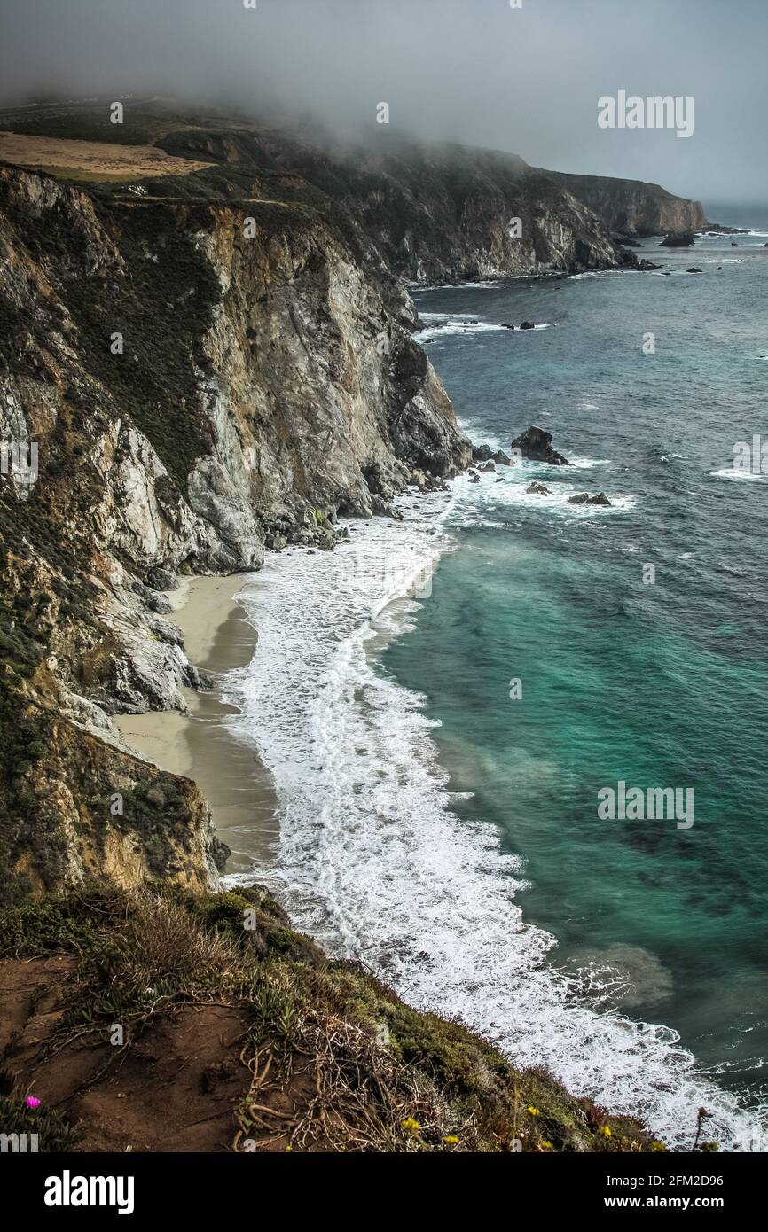 Panoramabild der wunderschönen Küste von Big Sur in Kalifornien an einem nebligen Tag, den Vereinigten Staaten von Amerika aka USA. Schäumende Wellen im Ozean und felsiger Berg Stockfoto