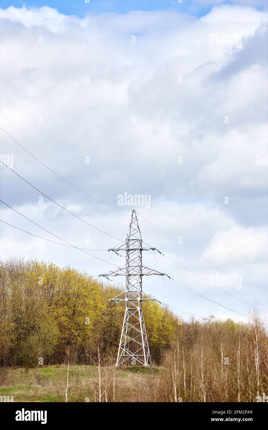 Hochspannungs-elektrische Hochspannungs-elektrische Übertragung Power Tower mit Elektrische Glasisolator von über bewölkt stürmischen dunklen Himmel in der Nähe Frühlingswald Stockfoto