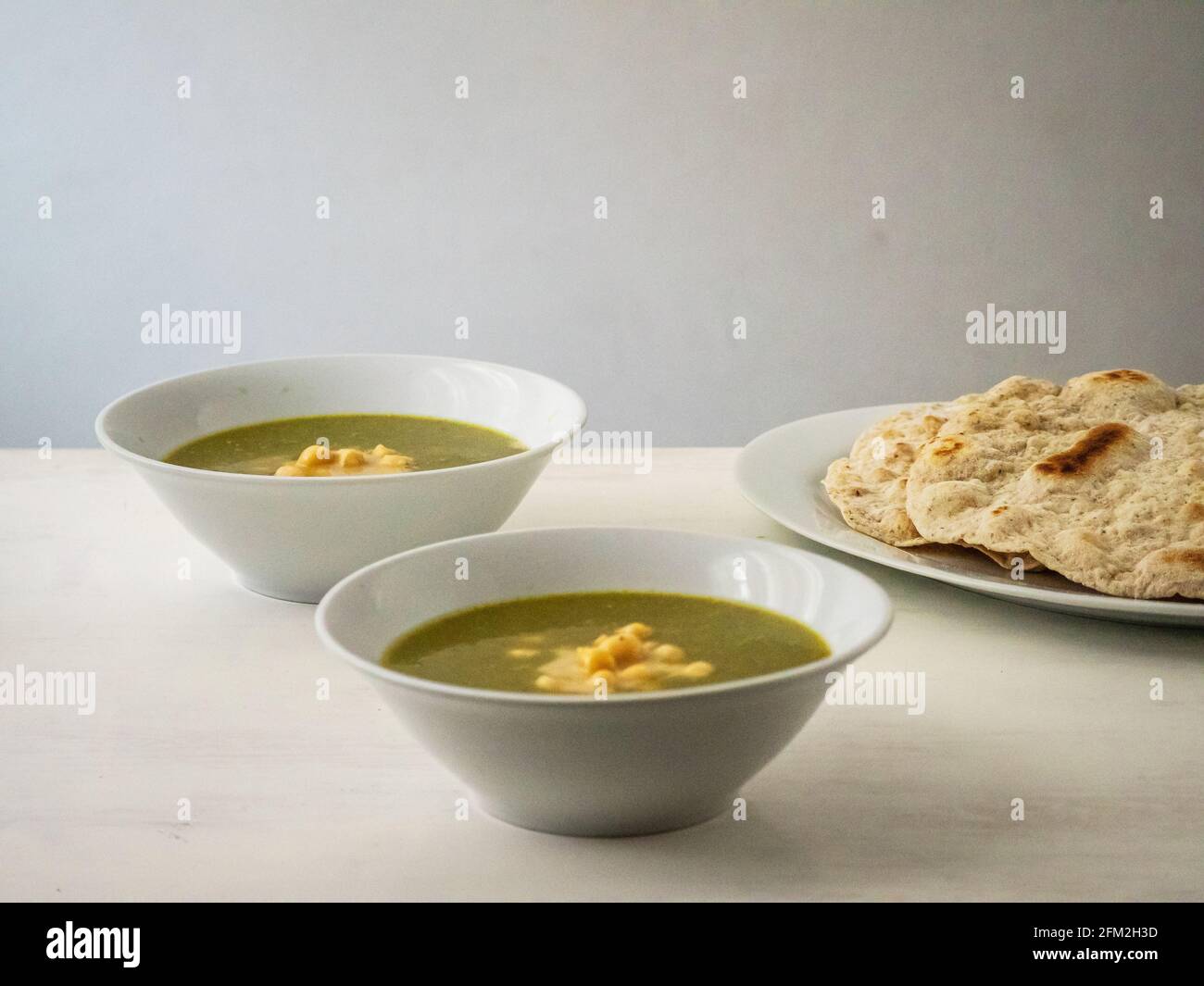 Molokhia (Juden Malge, Jute Malge, Malvenblätter) Einfache traditionelle ägyptische Suppe mit Kichererbsen und Fladenbrot Stockfoto