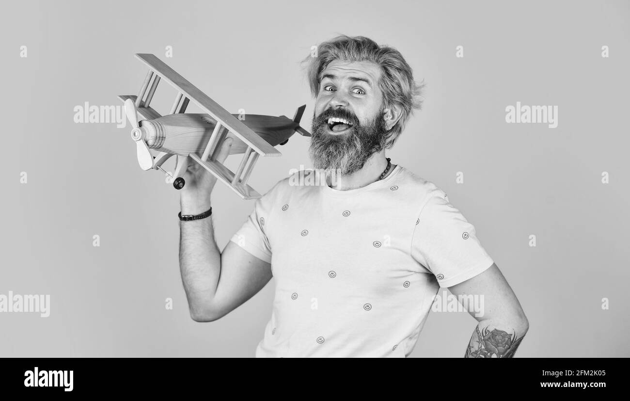 Kindheitstraum. Flieger bärtiger Hipster. Spielzeug aus Holz. Fliegen Sie mit dem Flugzeug. Buchen Sie Tickets Sommerurlaub. Mit Flugzeug spielen. Kabinenpersonal. Das ist es Stockfoto