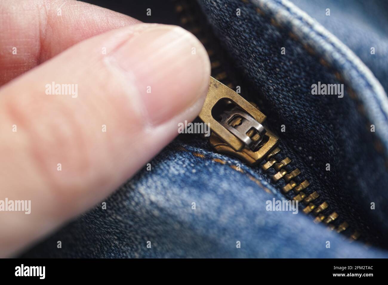 Eine Person, die ihre Jeans aufzippt. Nahaufnahme. Stockfoto