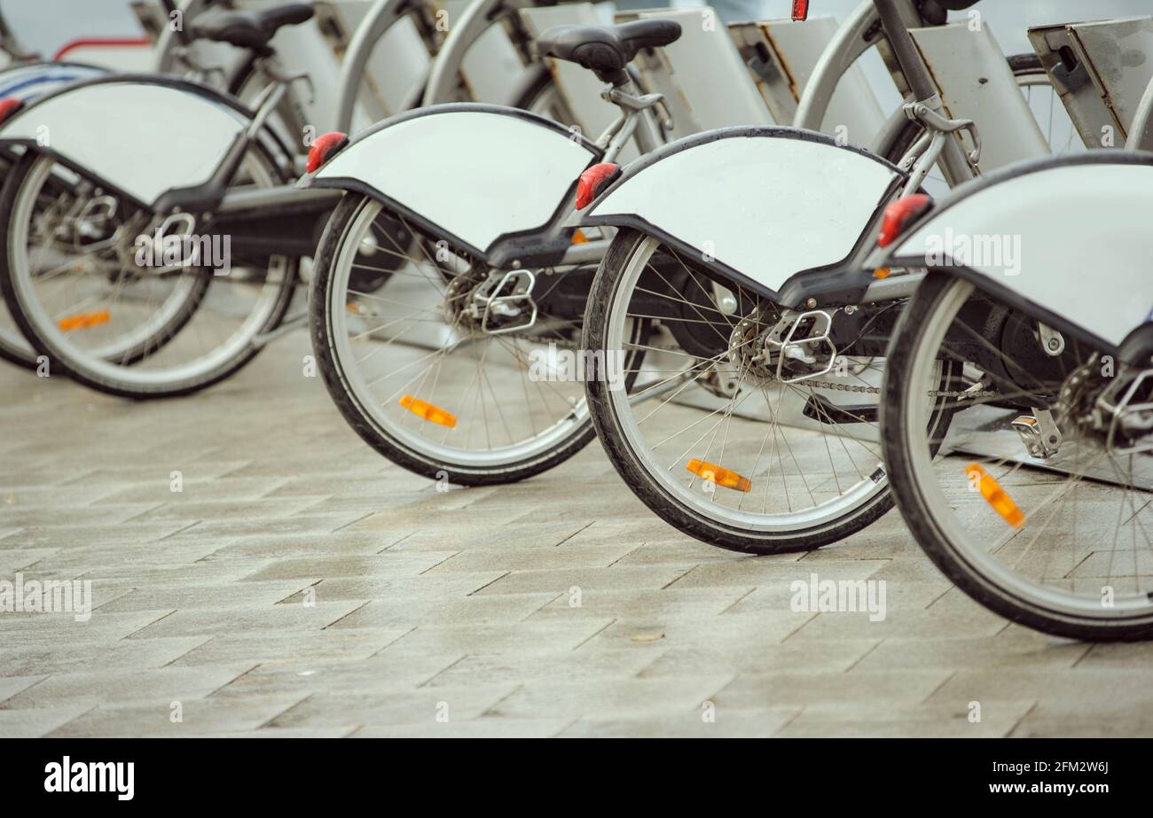 Reihe von Leihfahrrädern auf einer Straße an regnerischen Tagen Stockfoto