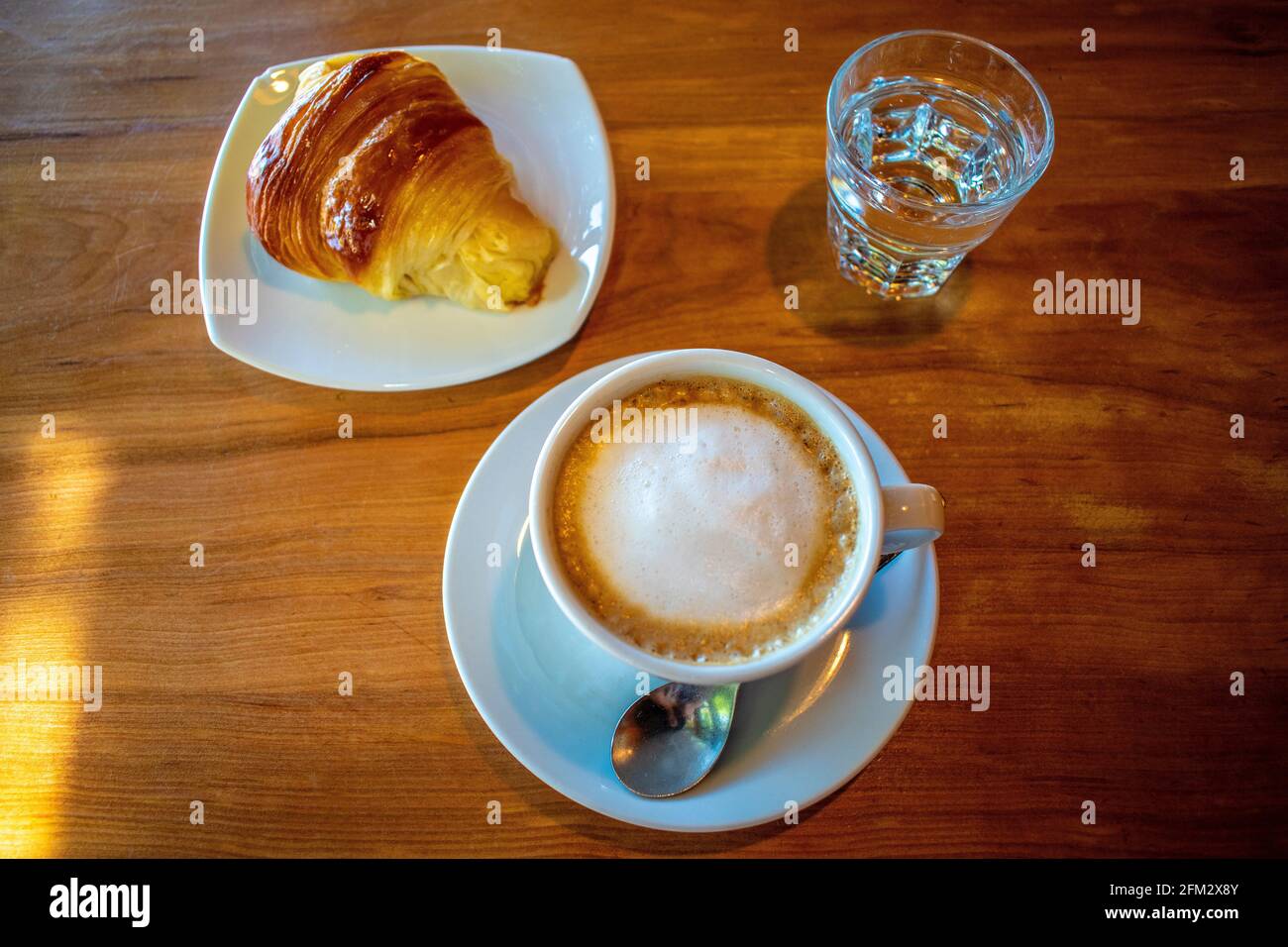 Kaffee mit Milch (Latte) und Buttercroissant. Stockfoto