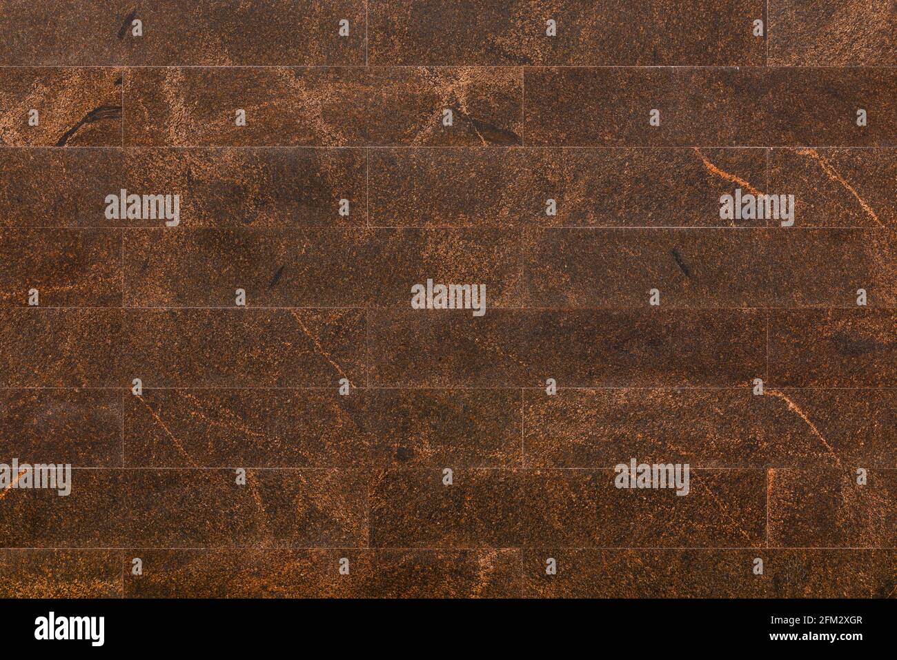 Flache Wand mit rechteckigen braunen Granitfliesen Auch bekannt als indischer brauner Granit Stockfoto