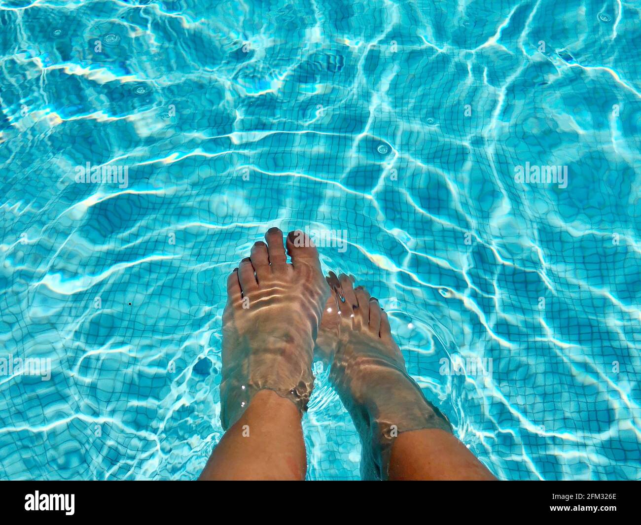 Ansicht von oben auf die Füße einer Frau in einem Schwimmbad, Frankreich Stockfoto